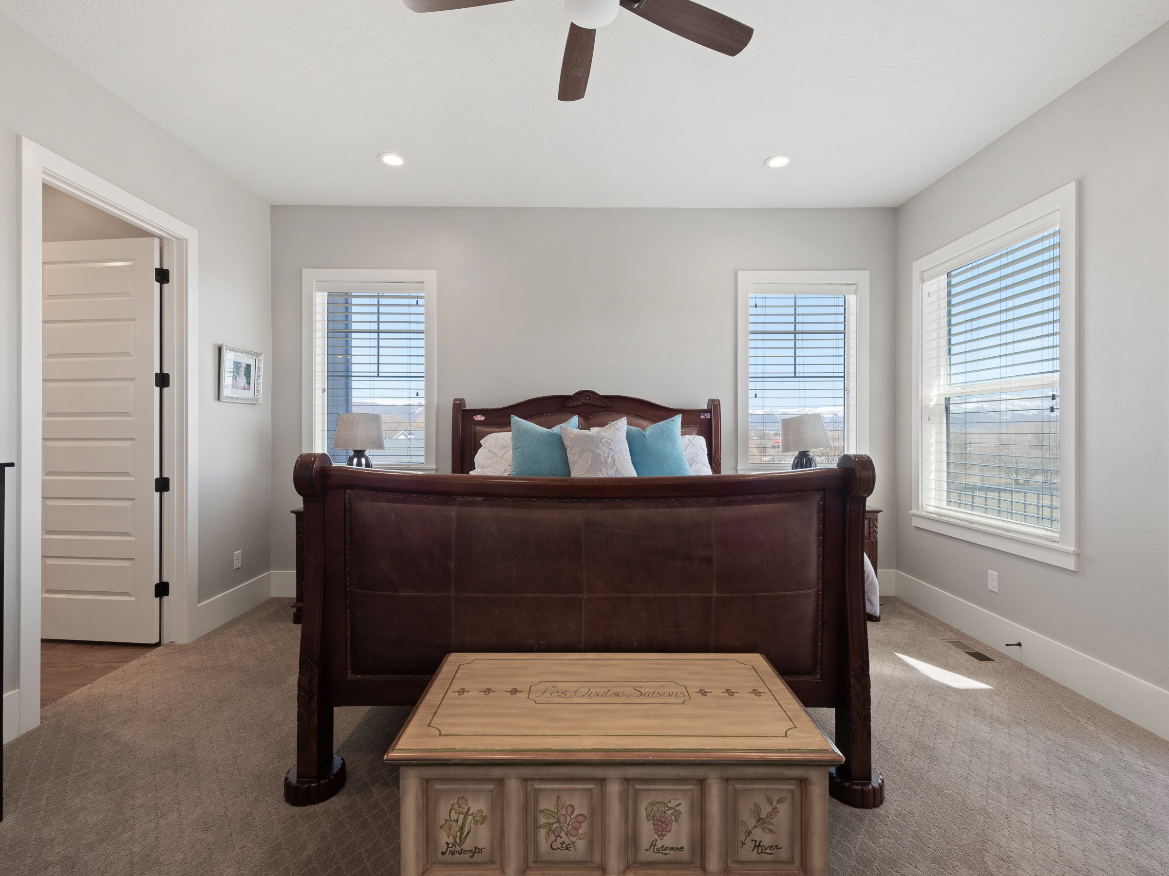 Carpeted room featuring a ceiling fan with integrated lighting, recessed lighting, and two windows with blinds