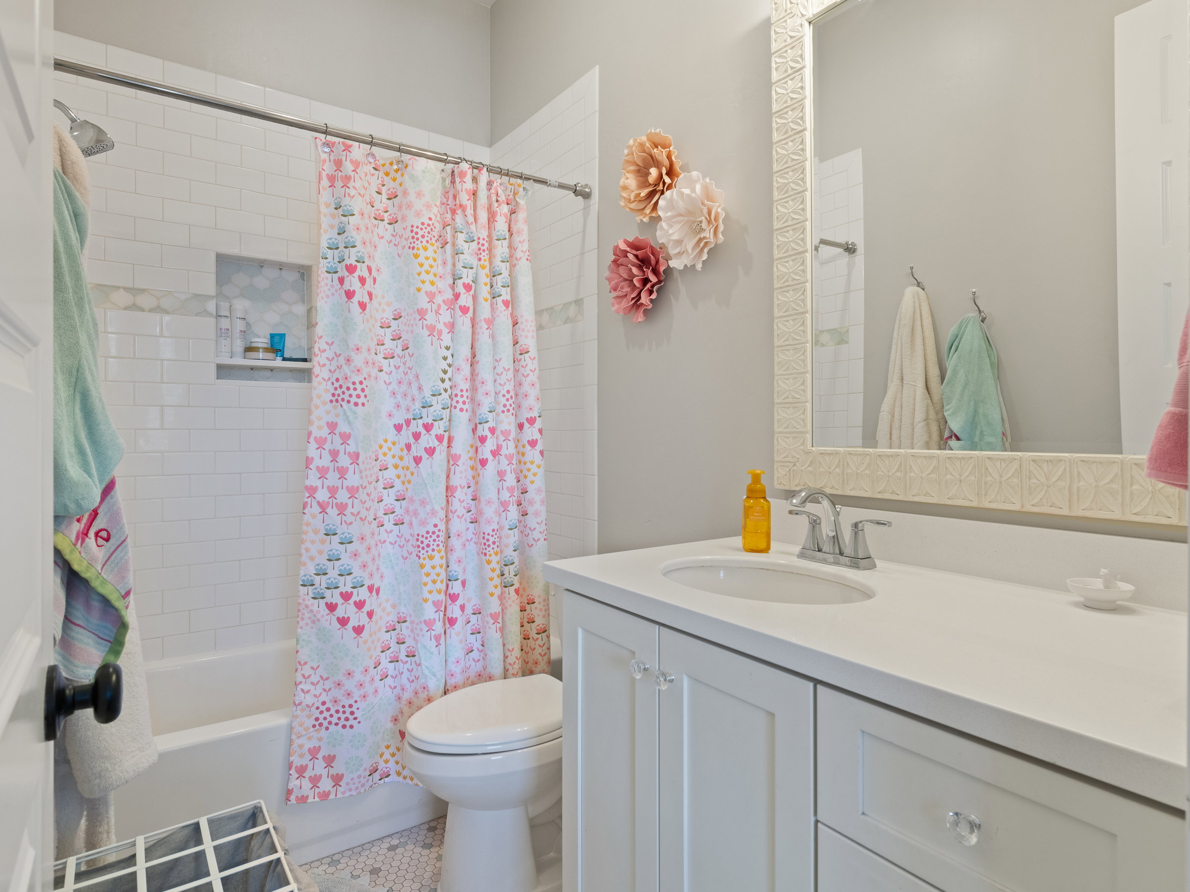 Bathroom vanity featuring a single basin, a white countertop, and white cabinetry with clear knobs