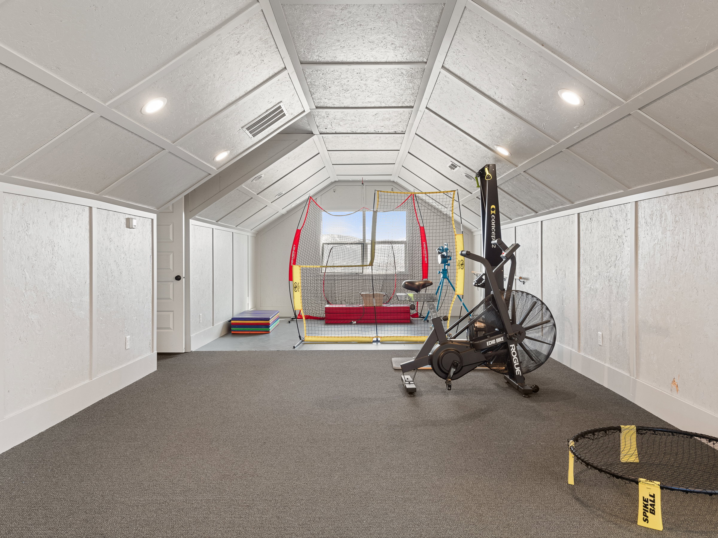 Attic space featuring sloped ceilings, recessed lighting, and integrated wall paneling