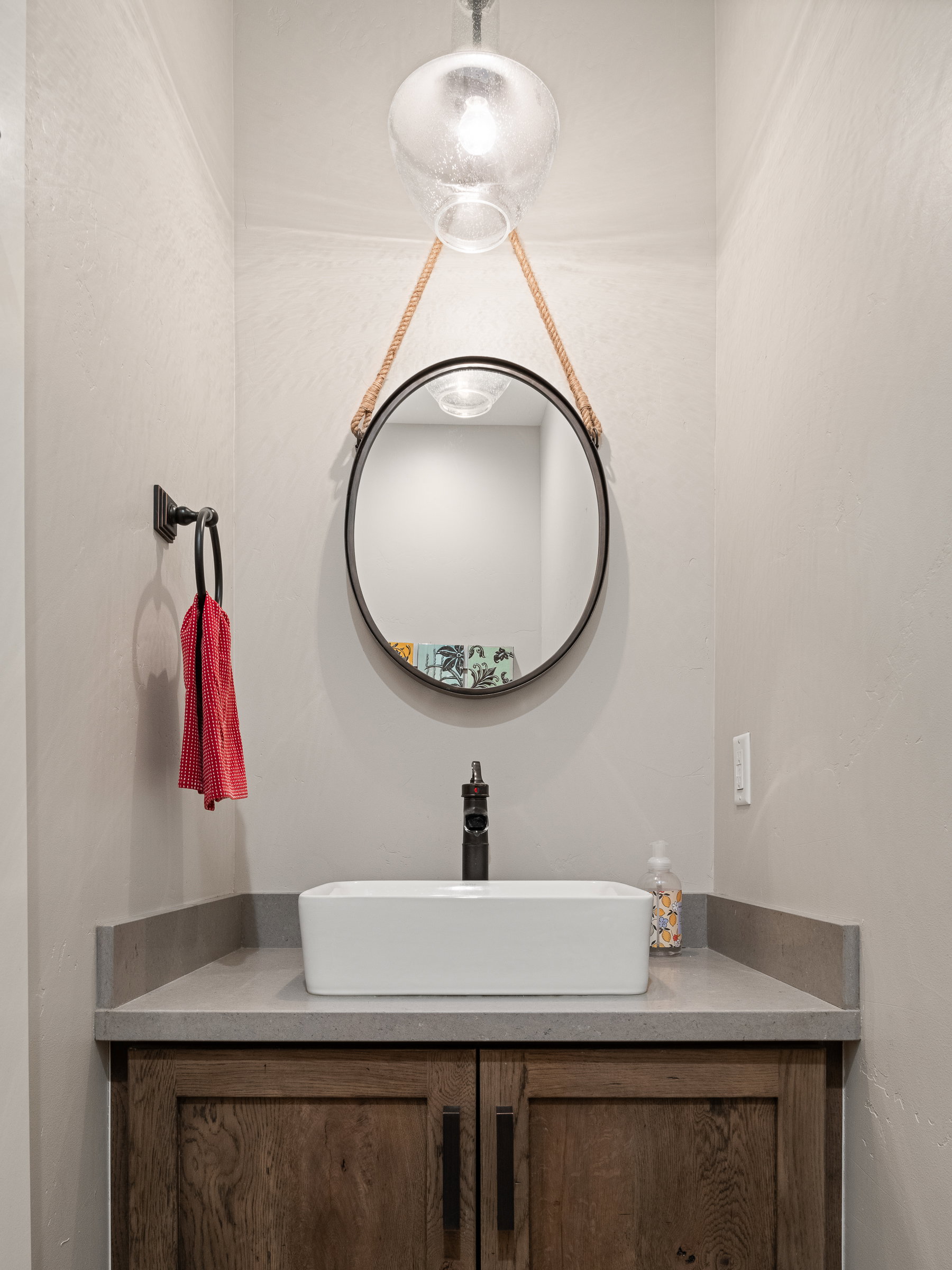 Modern vanity featuring a vessel sink, dark wood-finish cabinetry, and a stone countertop