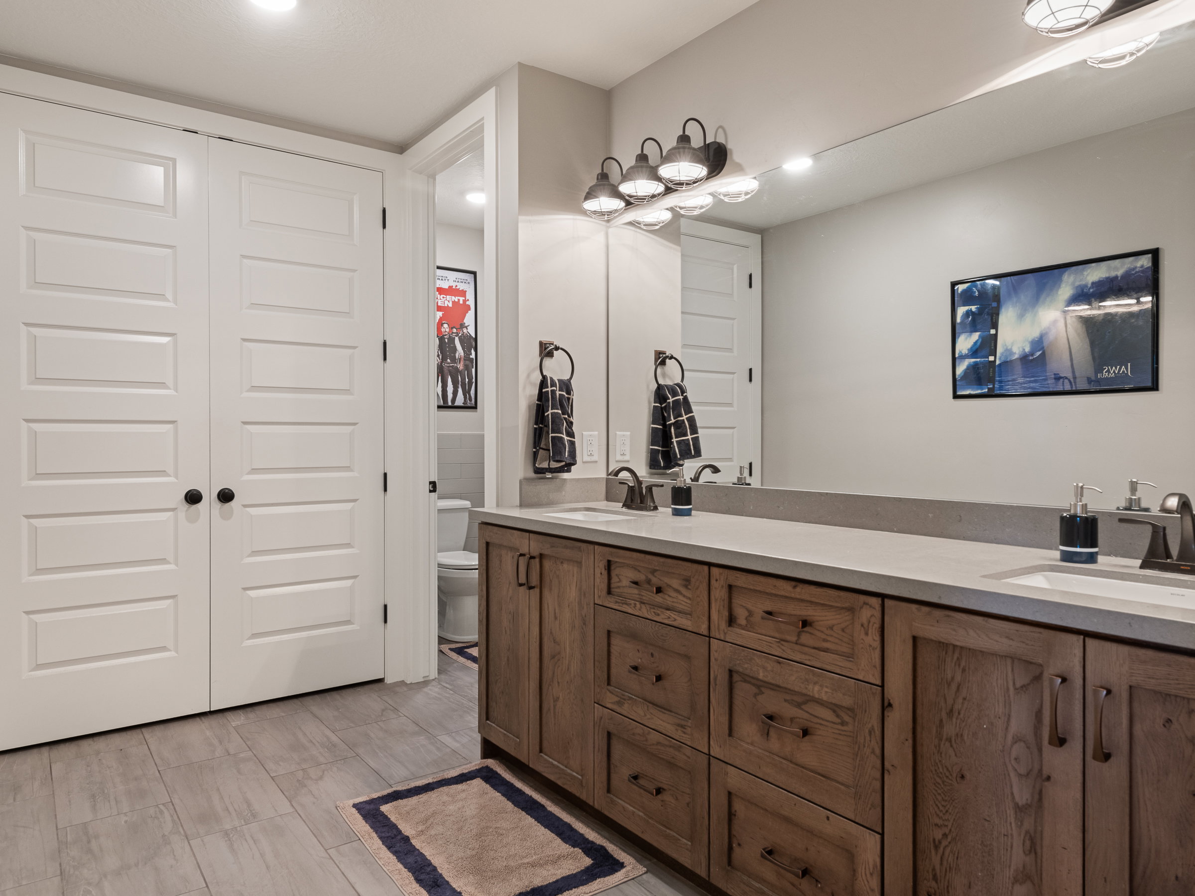 Double vanity with wood-finish cabinetry and light-toned countertops