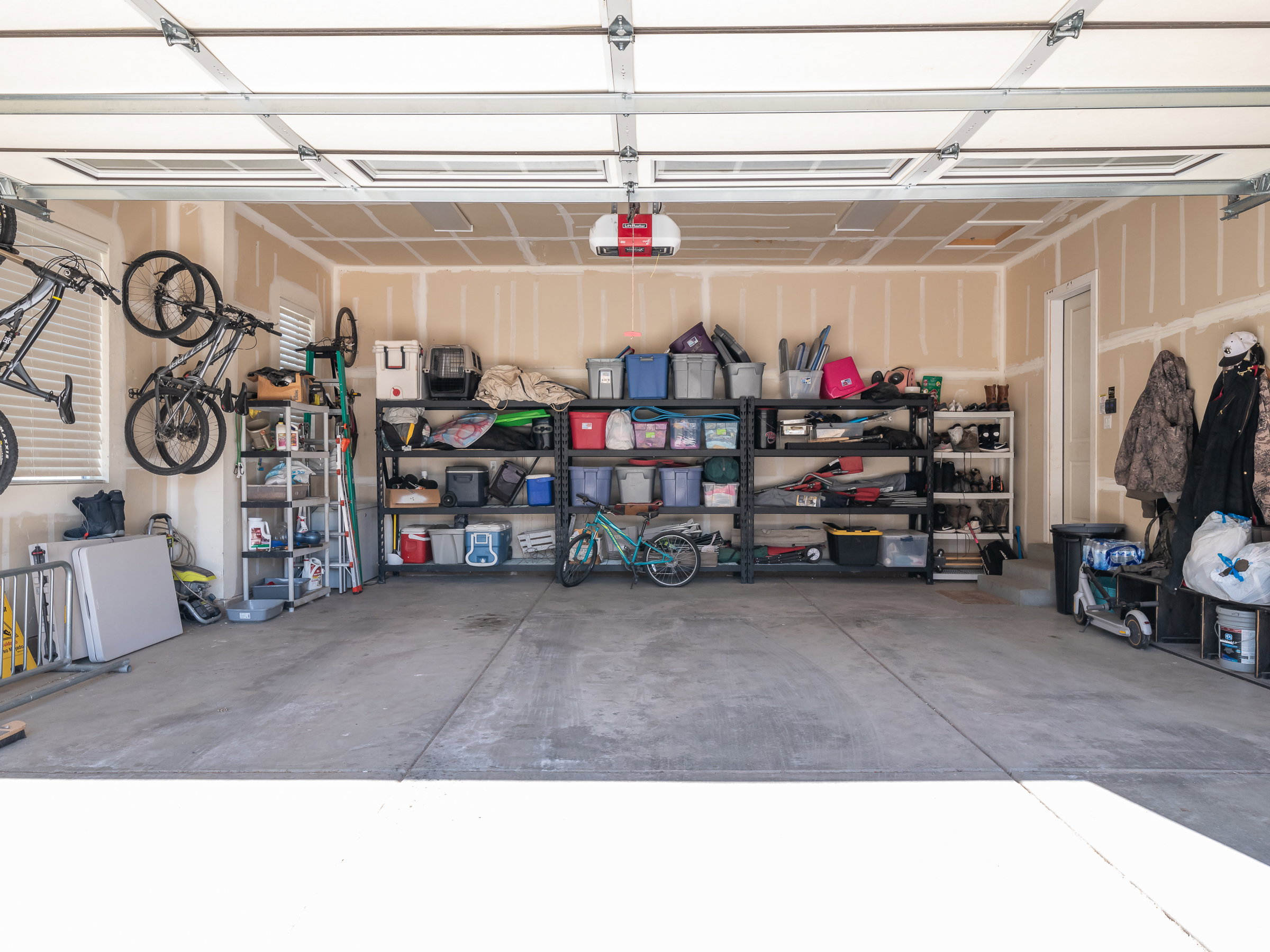 Spacious garage featuring a concrete floor, overhead garage door, and ample wall space