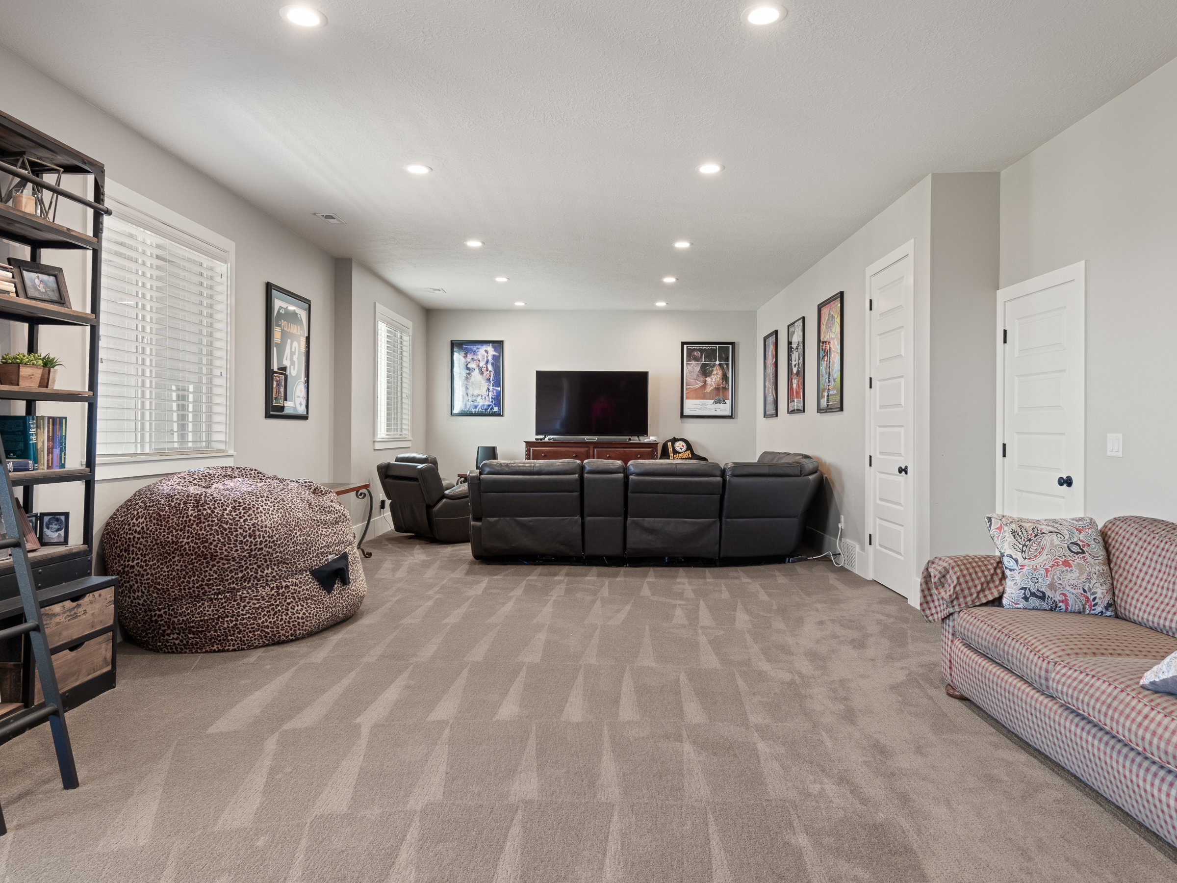 Spacious room featuring neutral carpeting, recessed lighting, and multiple windows with white blinds