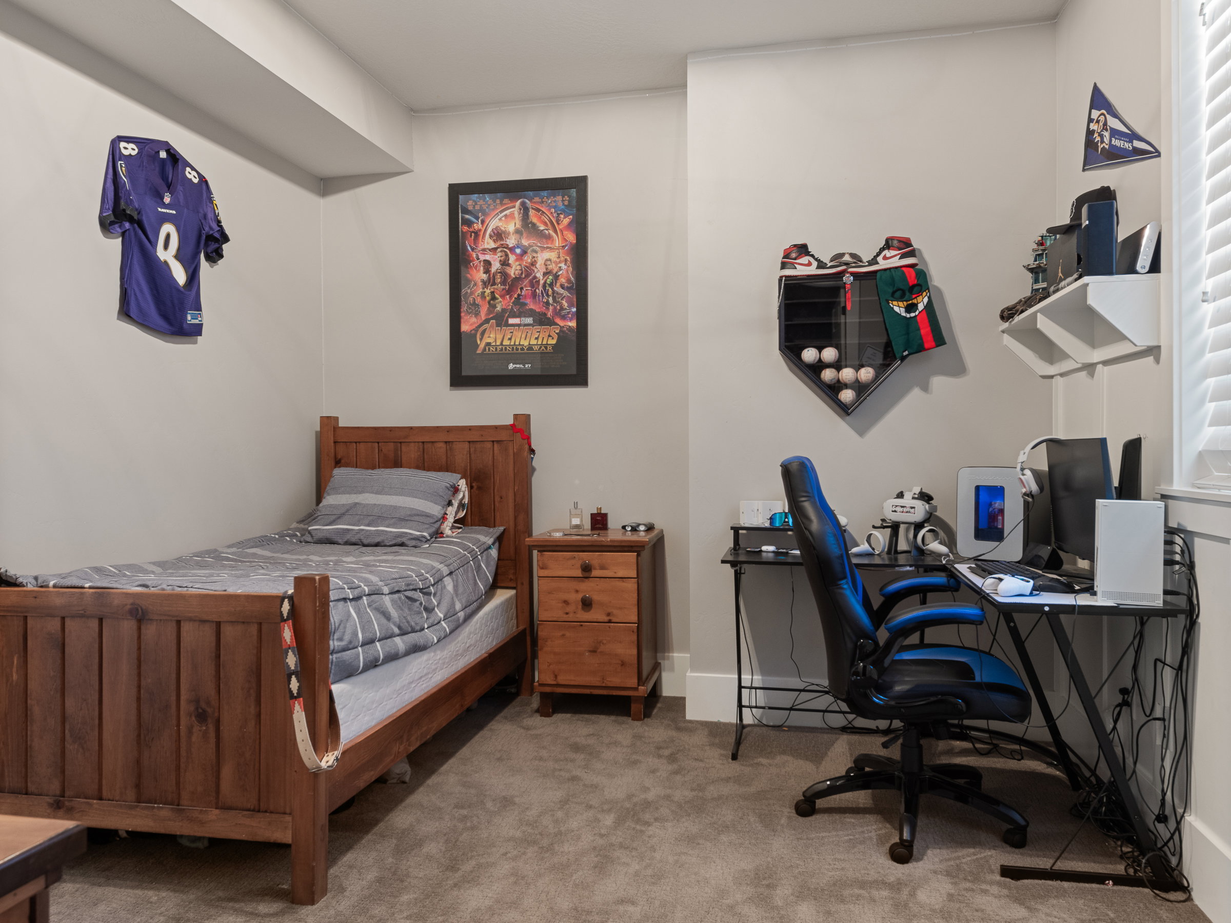 Carpeted room featuring light gray walls, a window with horizontal blinds, and a built-in ceiling beam