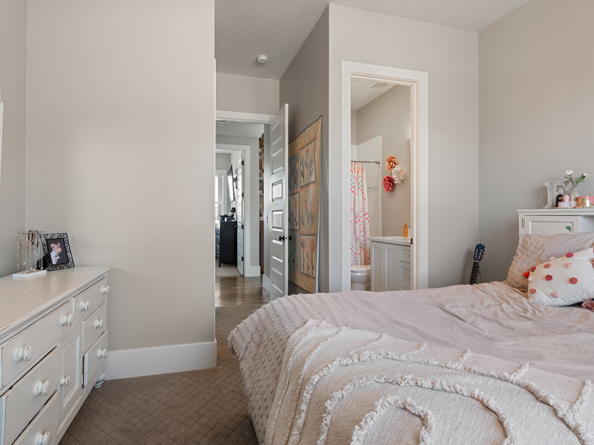 Neutral painted walls featuring a doorway leading to a full bathroom