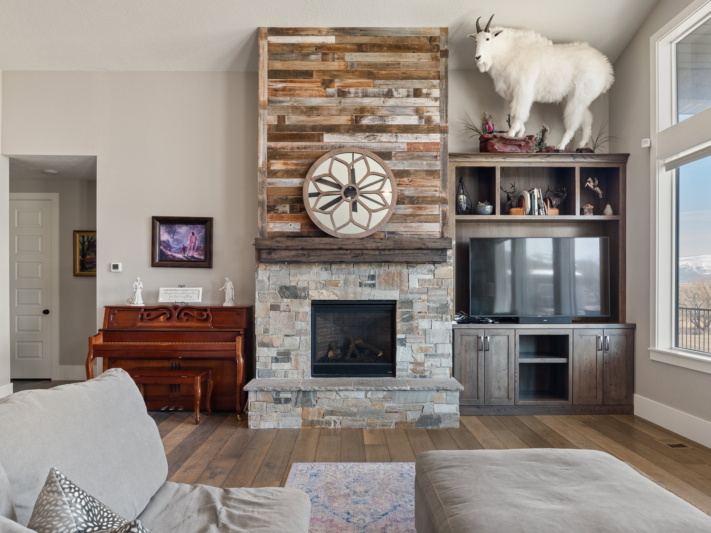 Central fireplace featuring a stone surround and wood-finish mantle