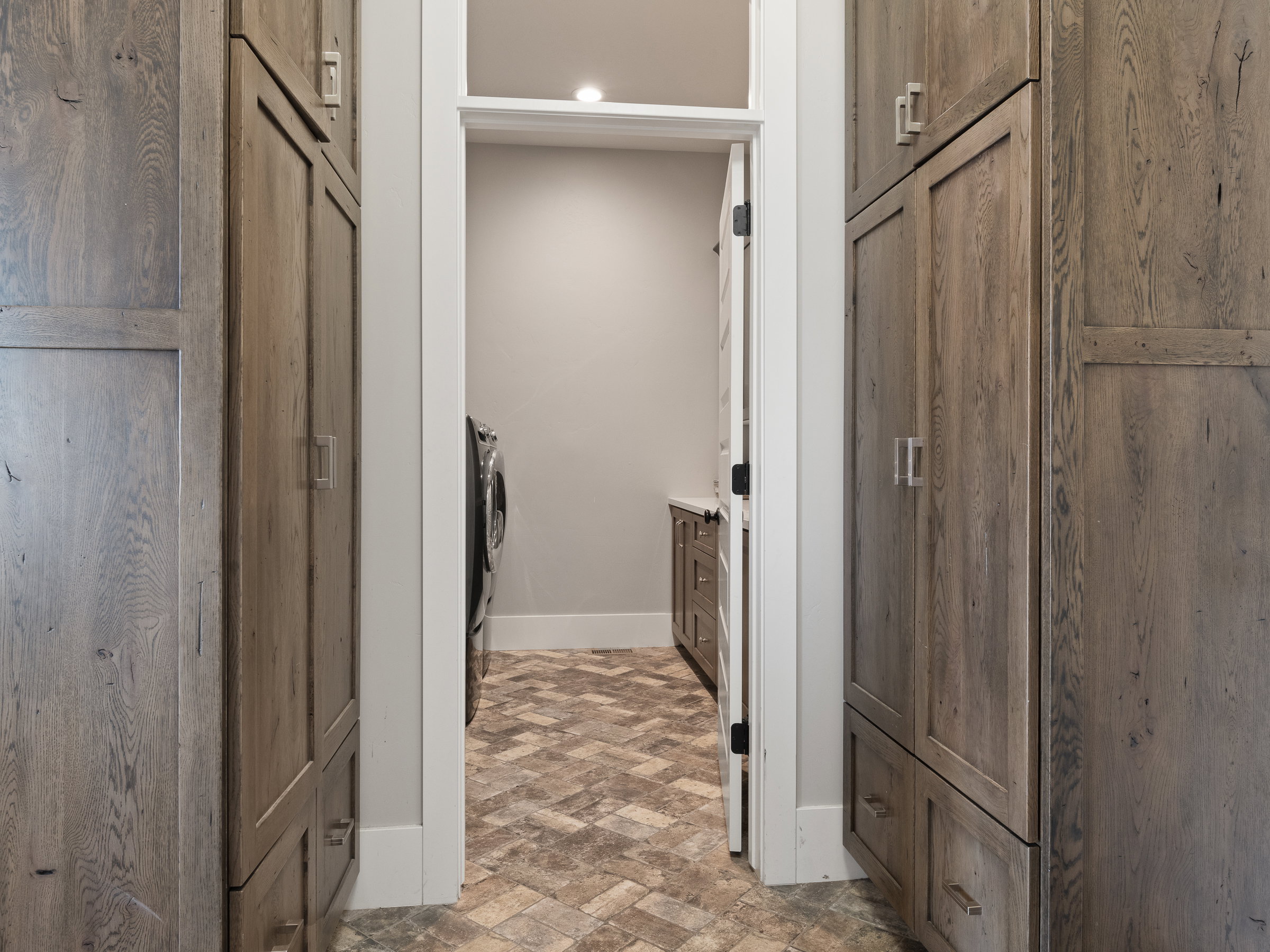Hallway featuring custom wood-finish cabinetry, contemporary hardware, and recessed lighting
