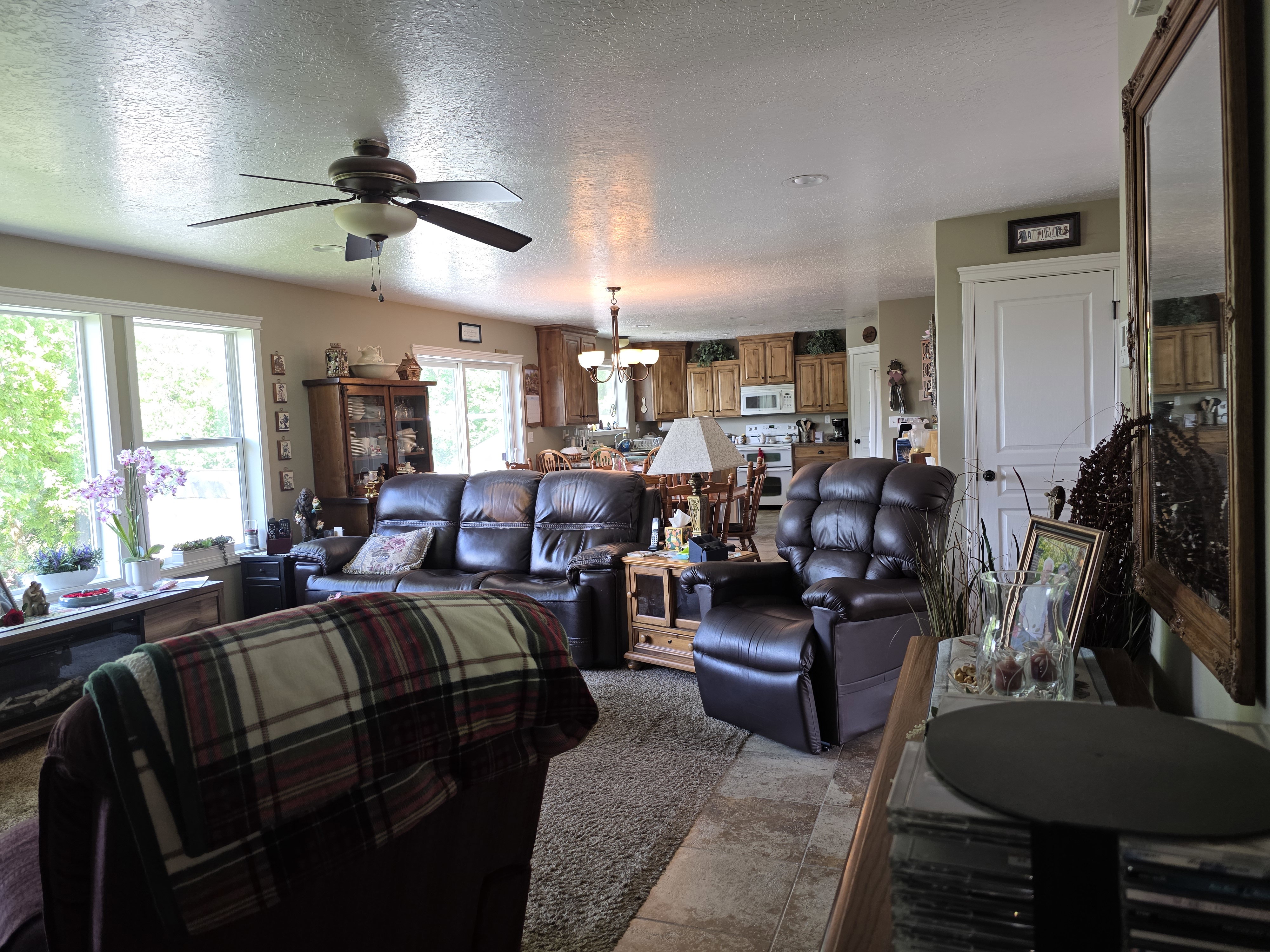 Open-concept living area with ample natural light, a ceiling fan, and recessed lighting