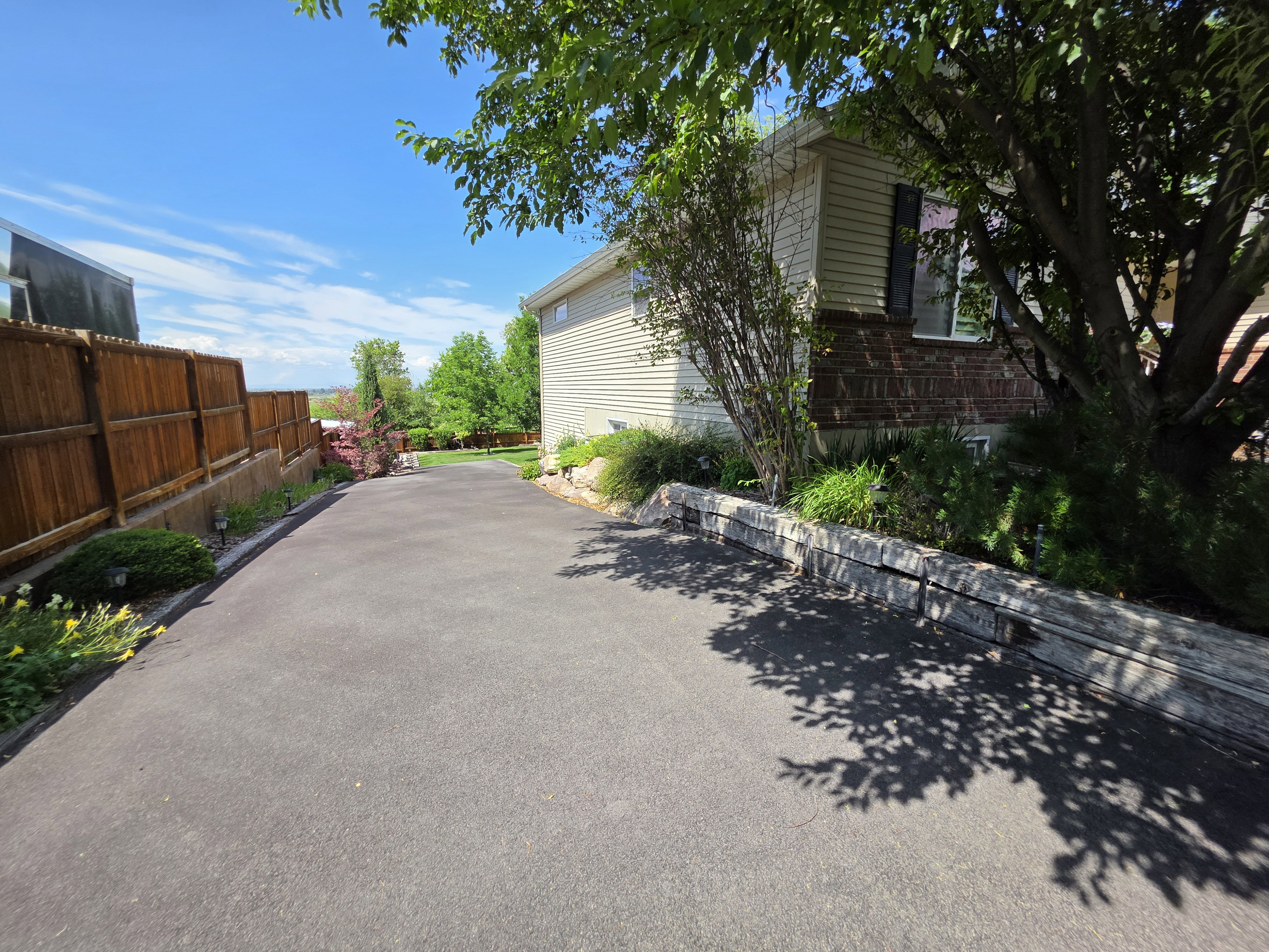 Paved driveway with timber-lined garden beds