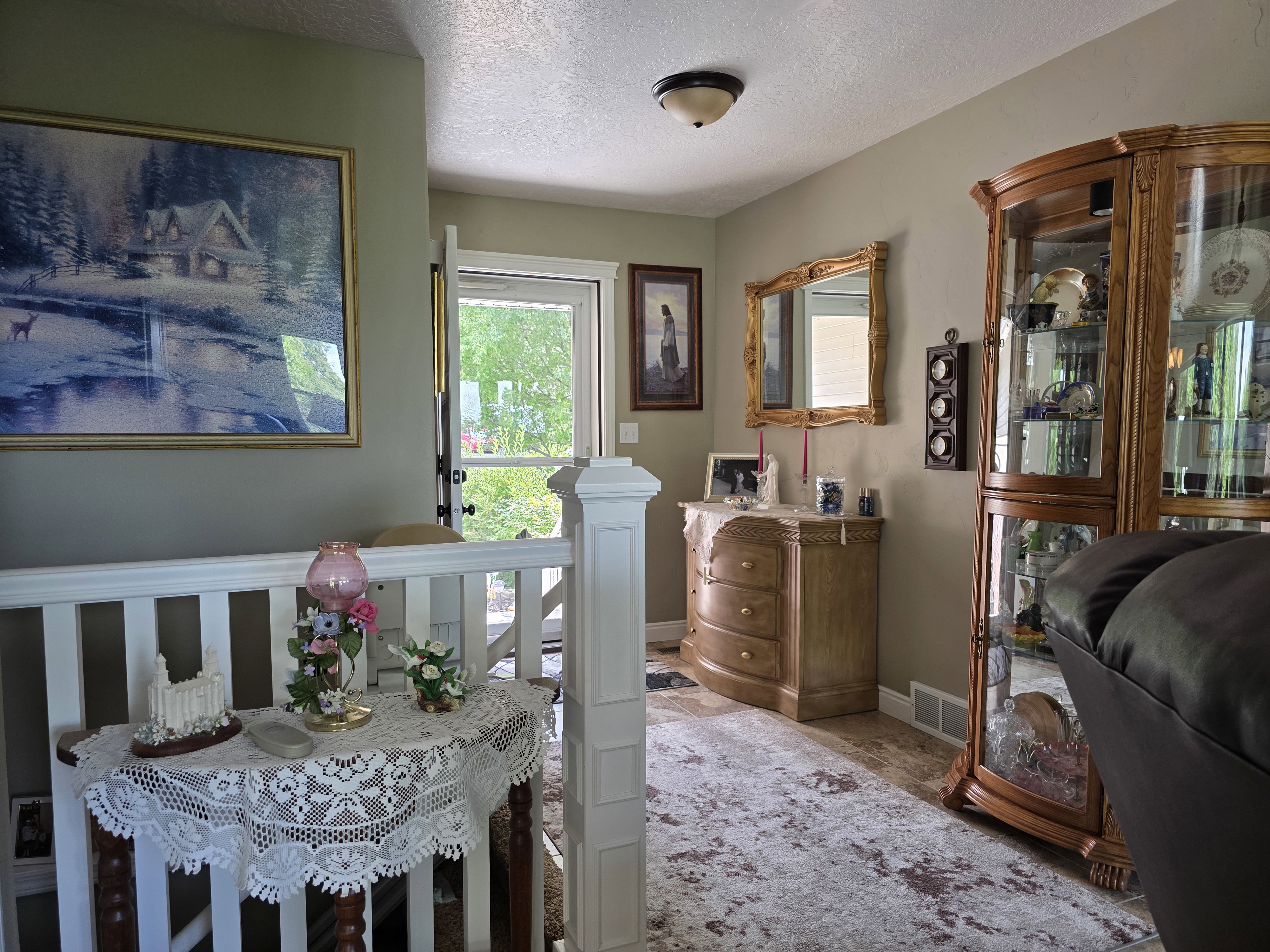Entryway featuring a white railing, a transom window above the door, and neutral wall tones