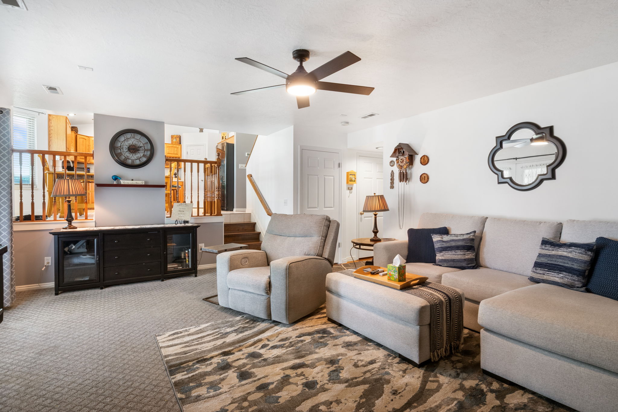 Lower-level living space featuring recessed lighting, a ceiling fan with integrated light, and neutral-toned wall paint