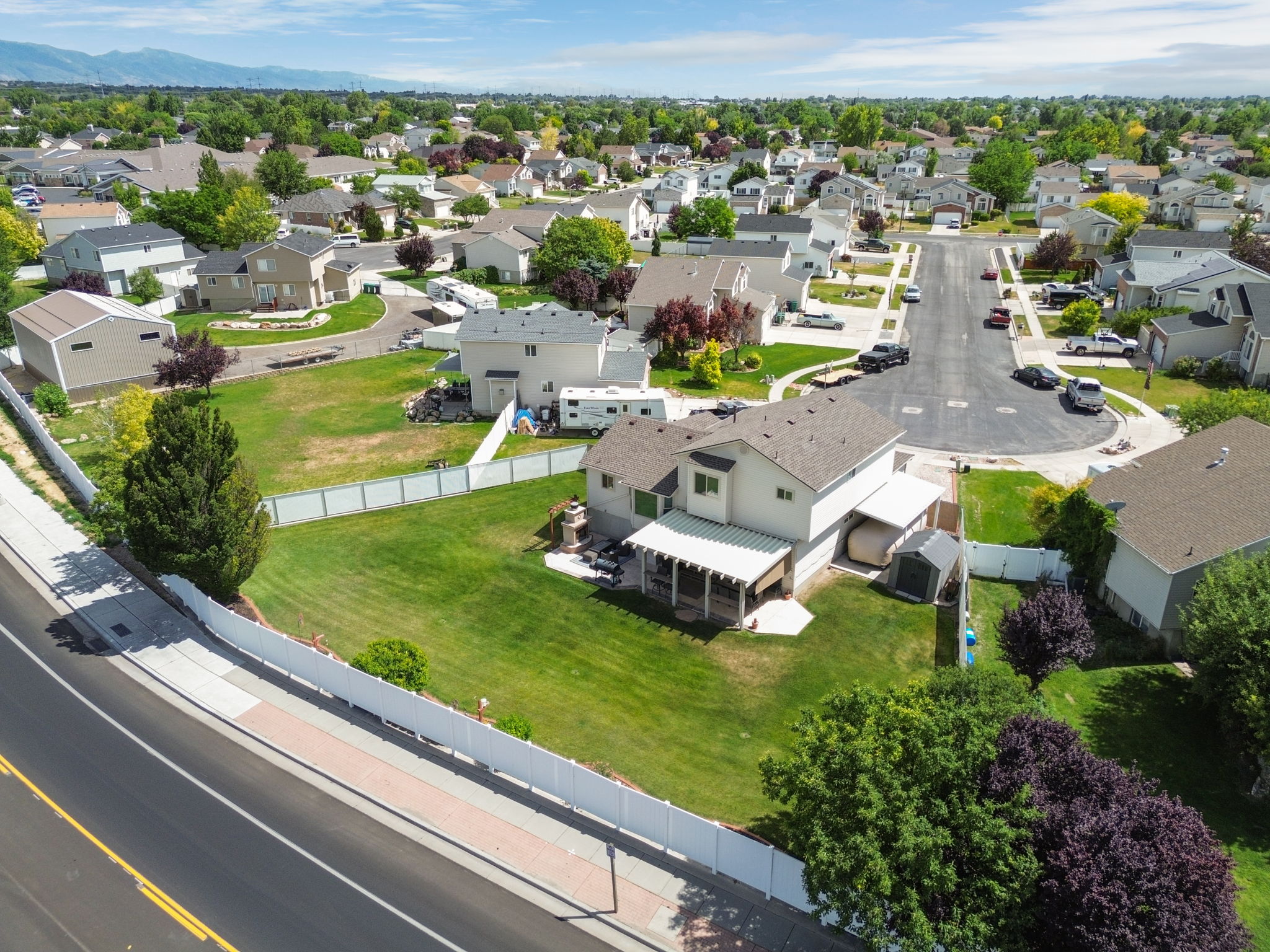Expansive lot featuring a large lawn area, full vinyl fencing, and a covered patio