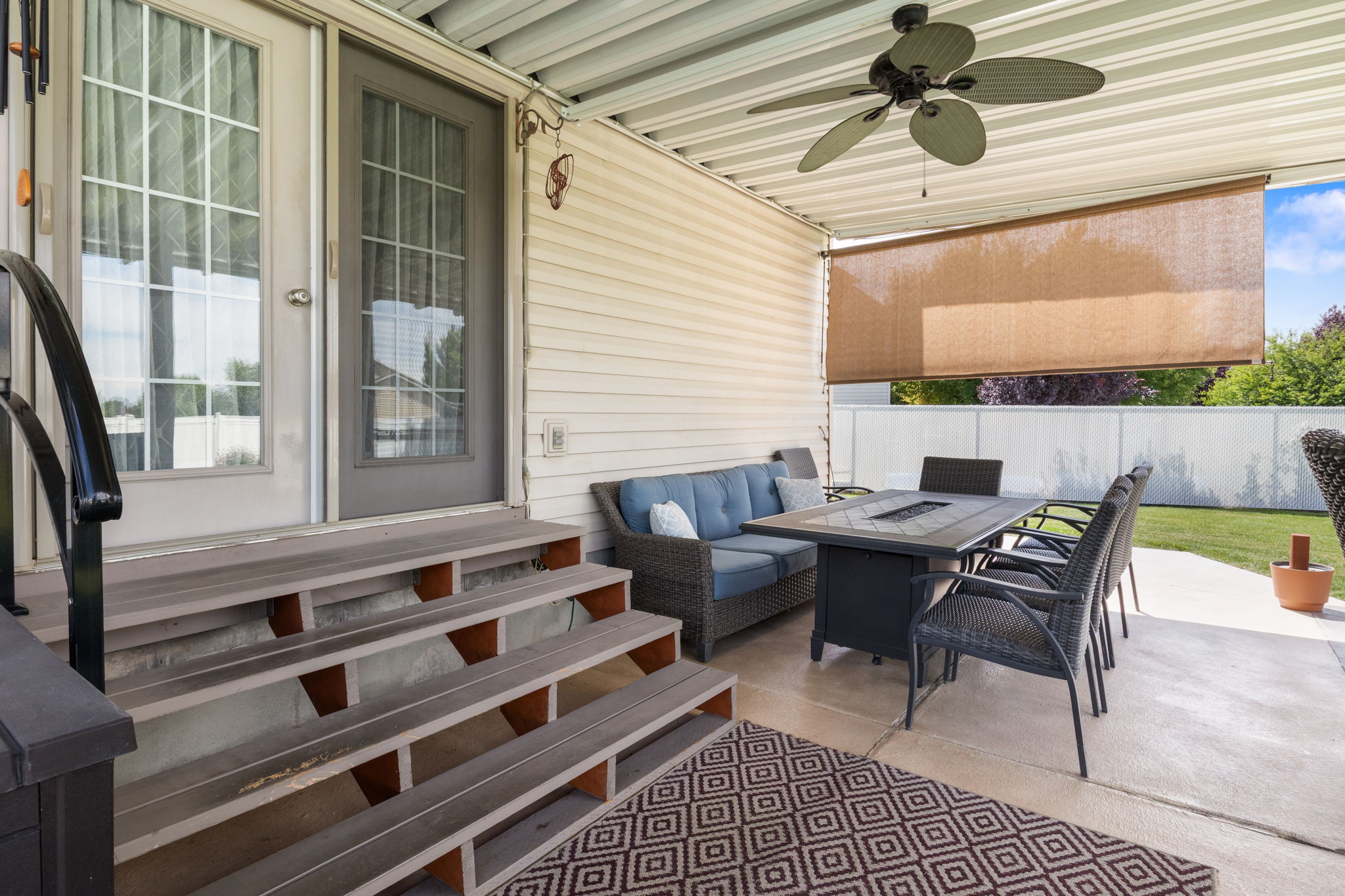 Covered patio featuring a ceiling fan, pull-down sun shade, and concrete flooring