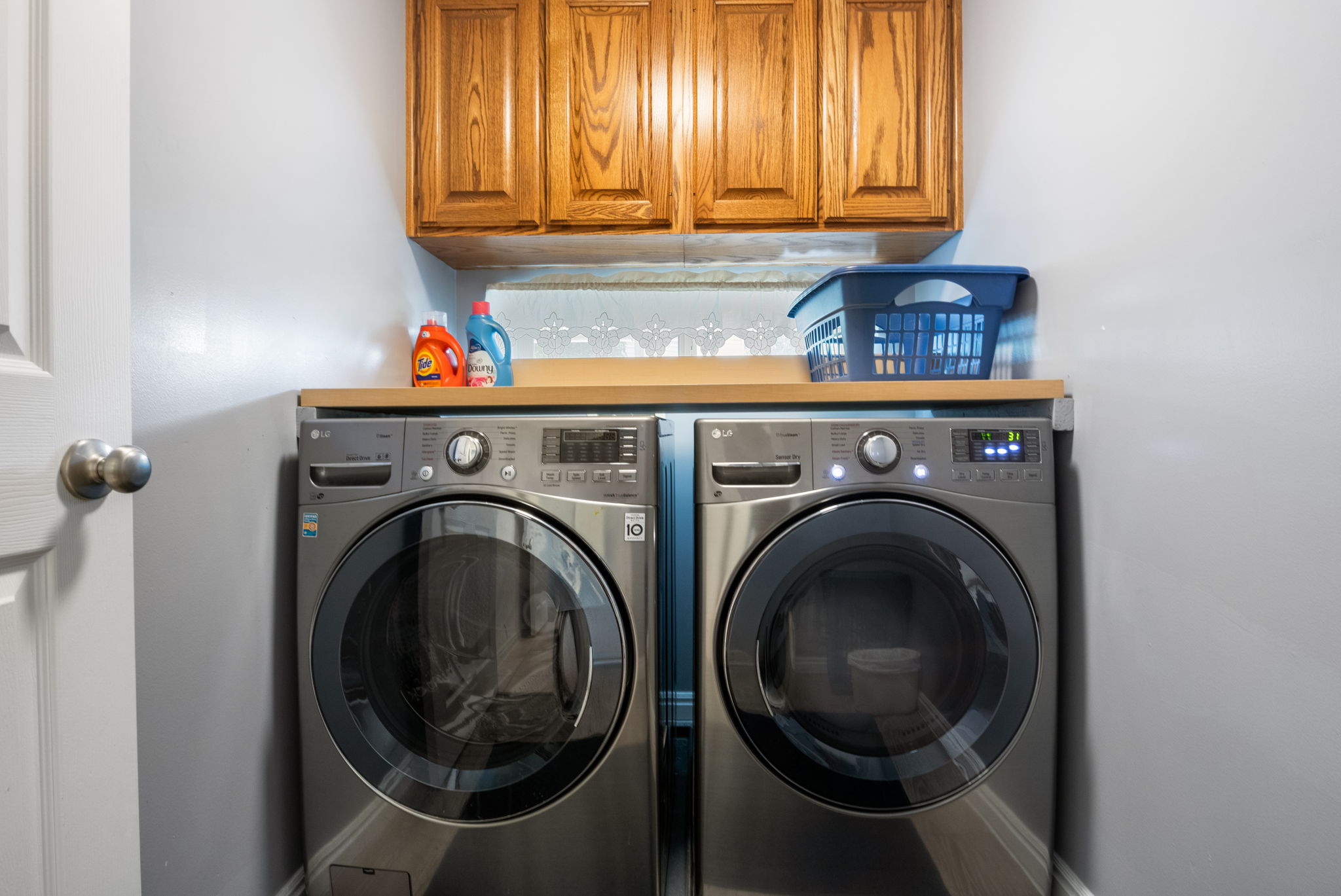 Dedicated laundry area with light wood-finish cabinetry
