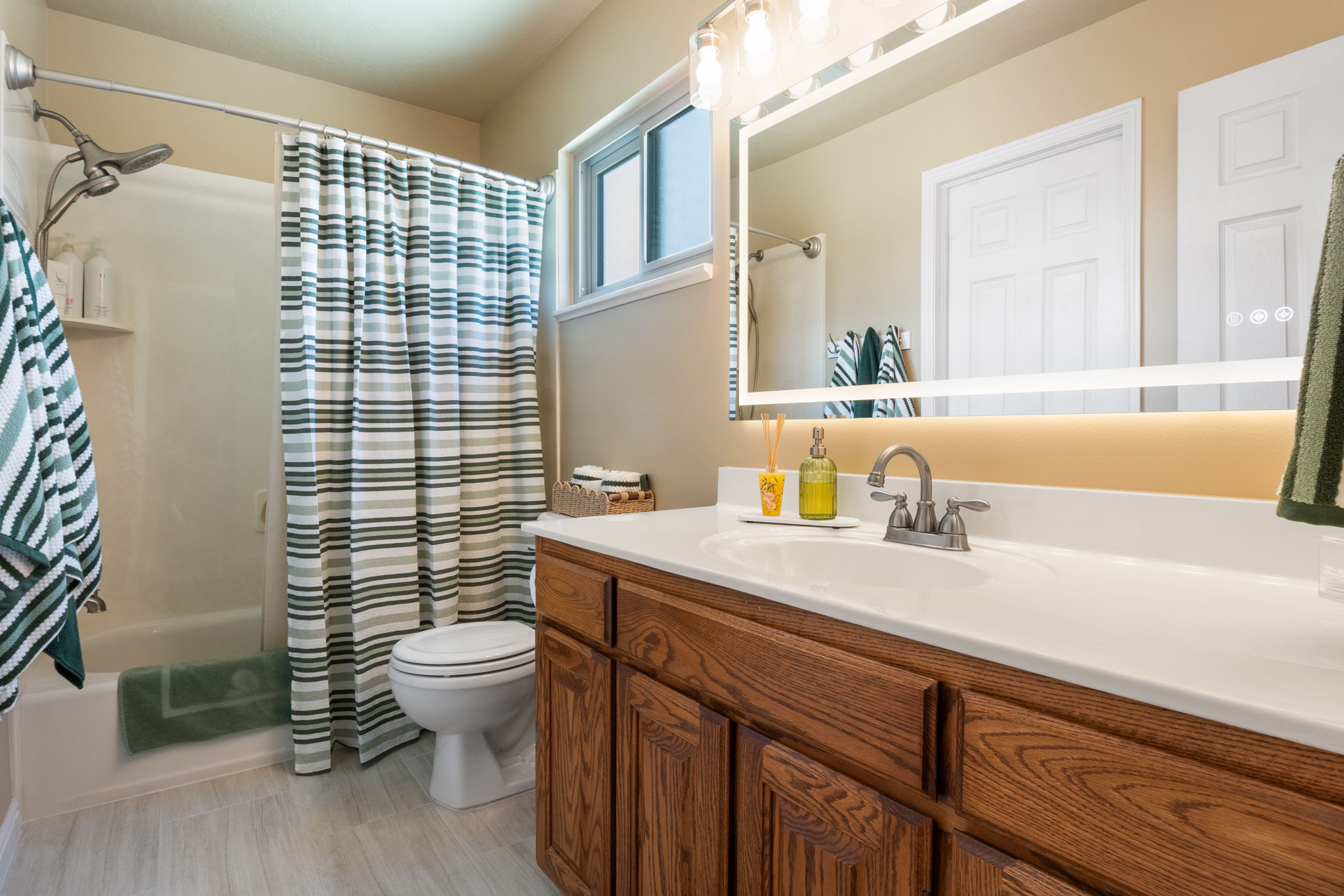 Bathroom featuring a spacious single vanity with a white countertop and wood-finish cabinetry