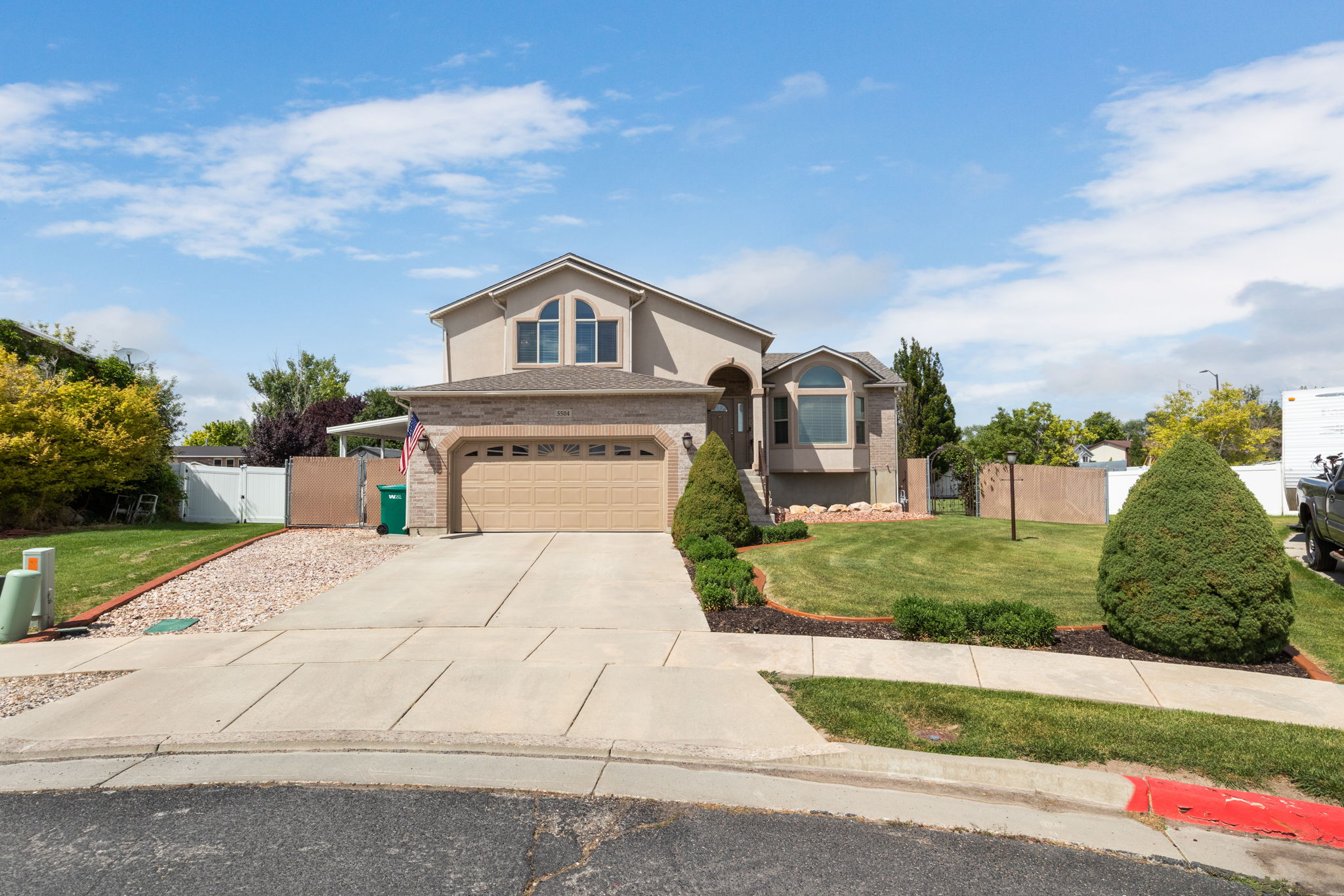 Beautiful residence featuring a two-car garage with a concrete driveway, arched entryways, and a bay window