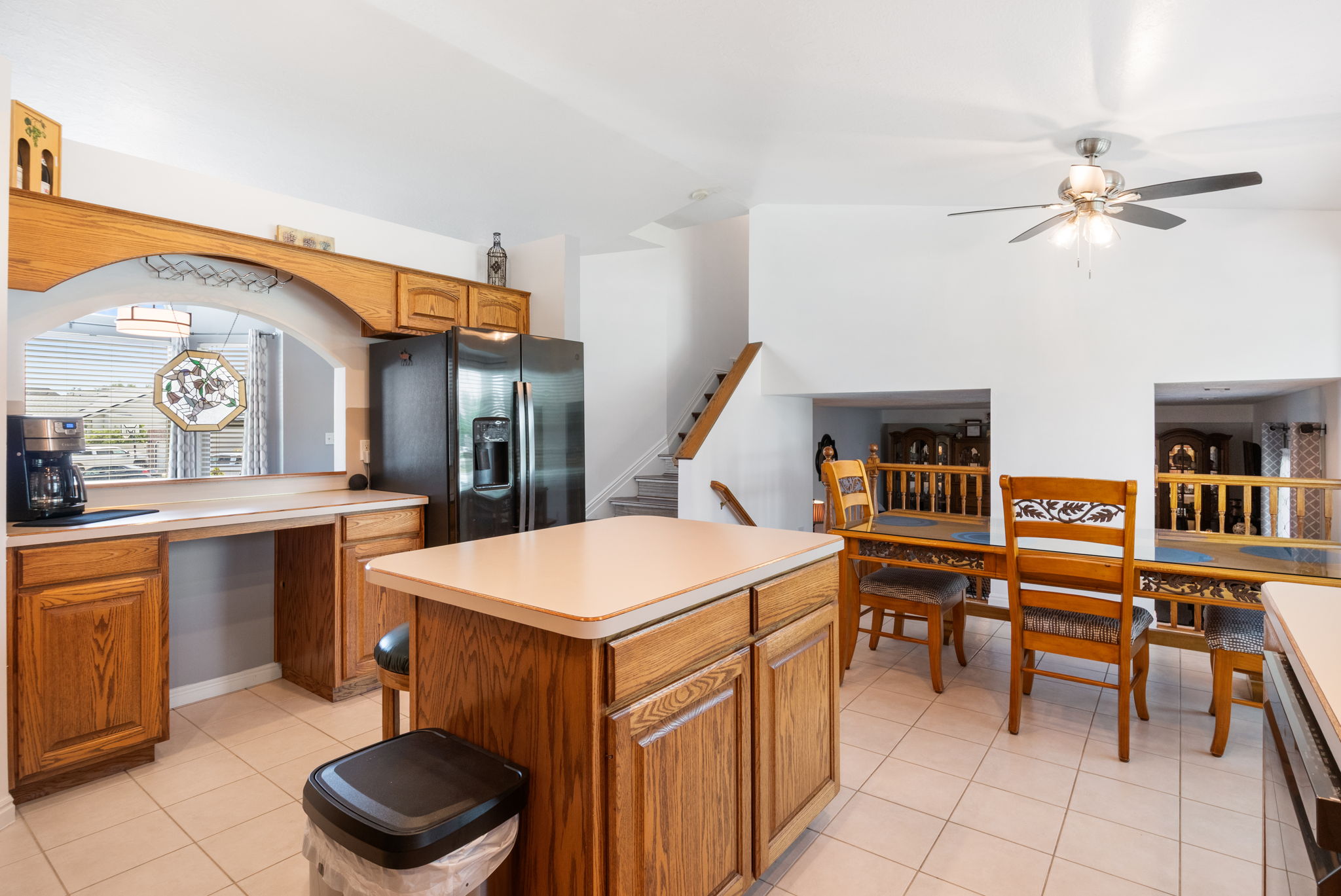 Kitchen featuring light wood cabinetry, a central island, and tile flooring