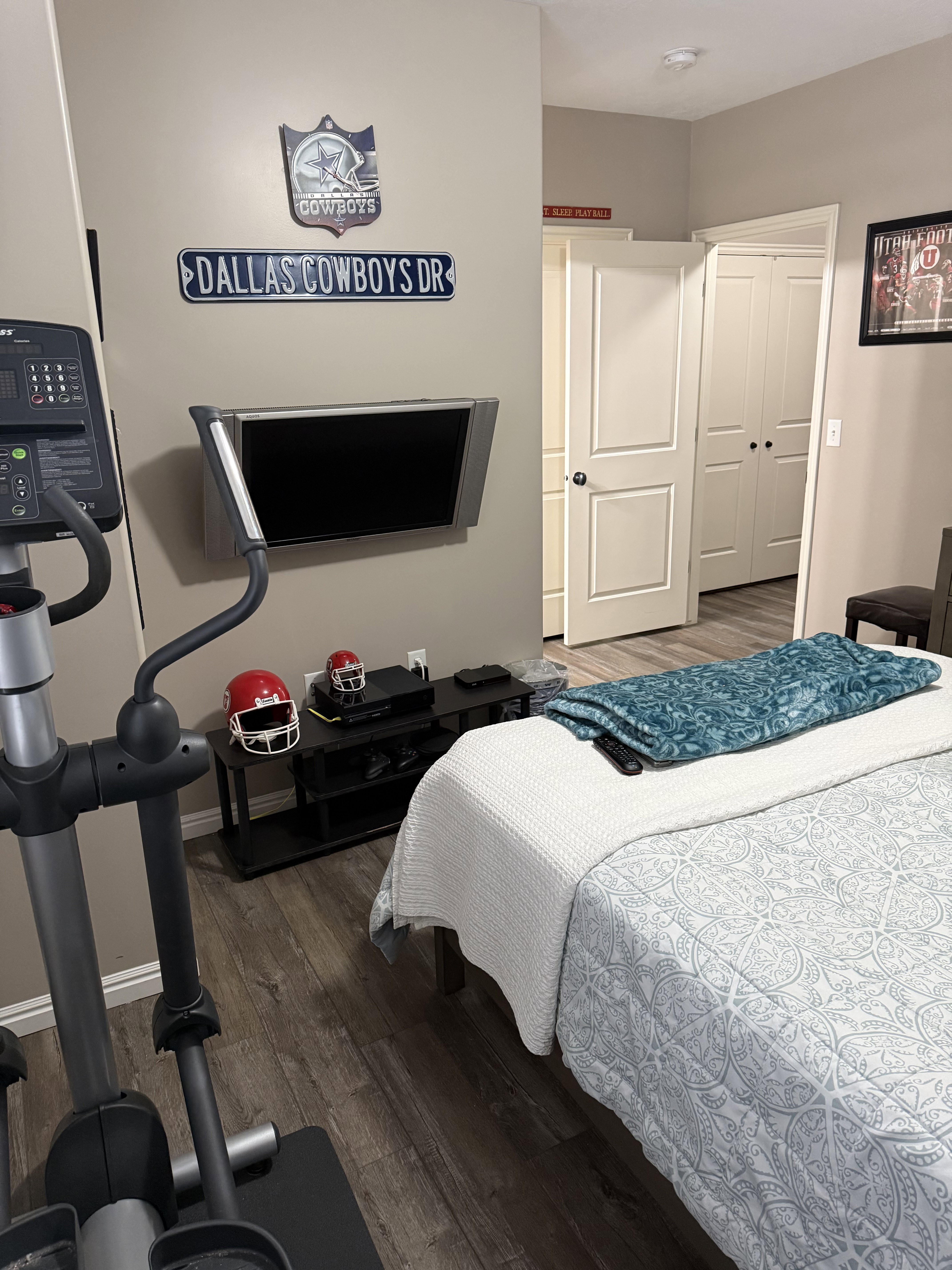 Bedroom featuring wood-finish flooring, a neutral wall color, and a wall-mounted television