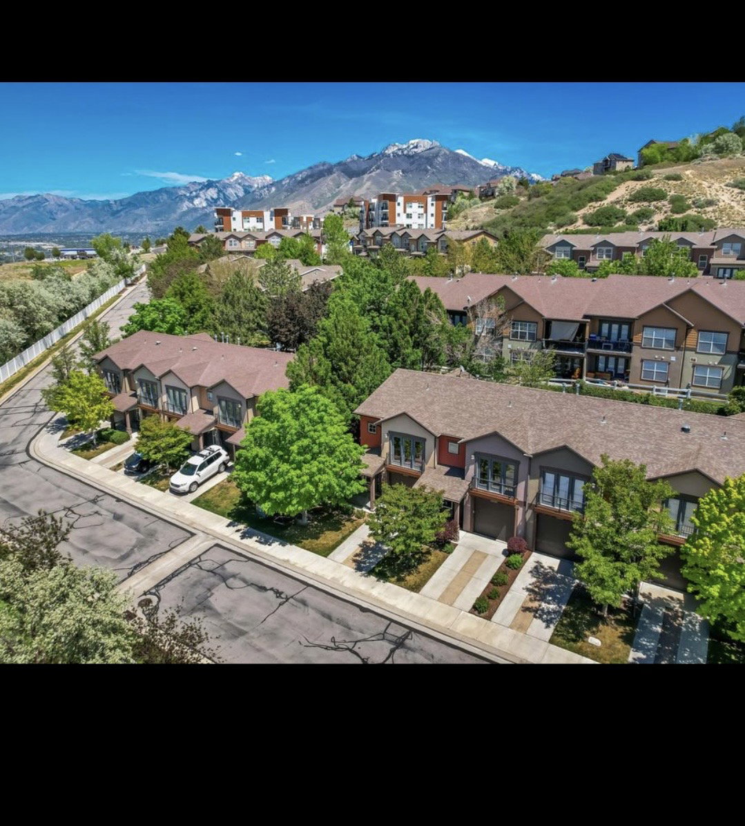 Contemporary townhomes featuring multi-tone exteriors, private garages, and individual driveway parking