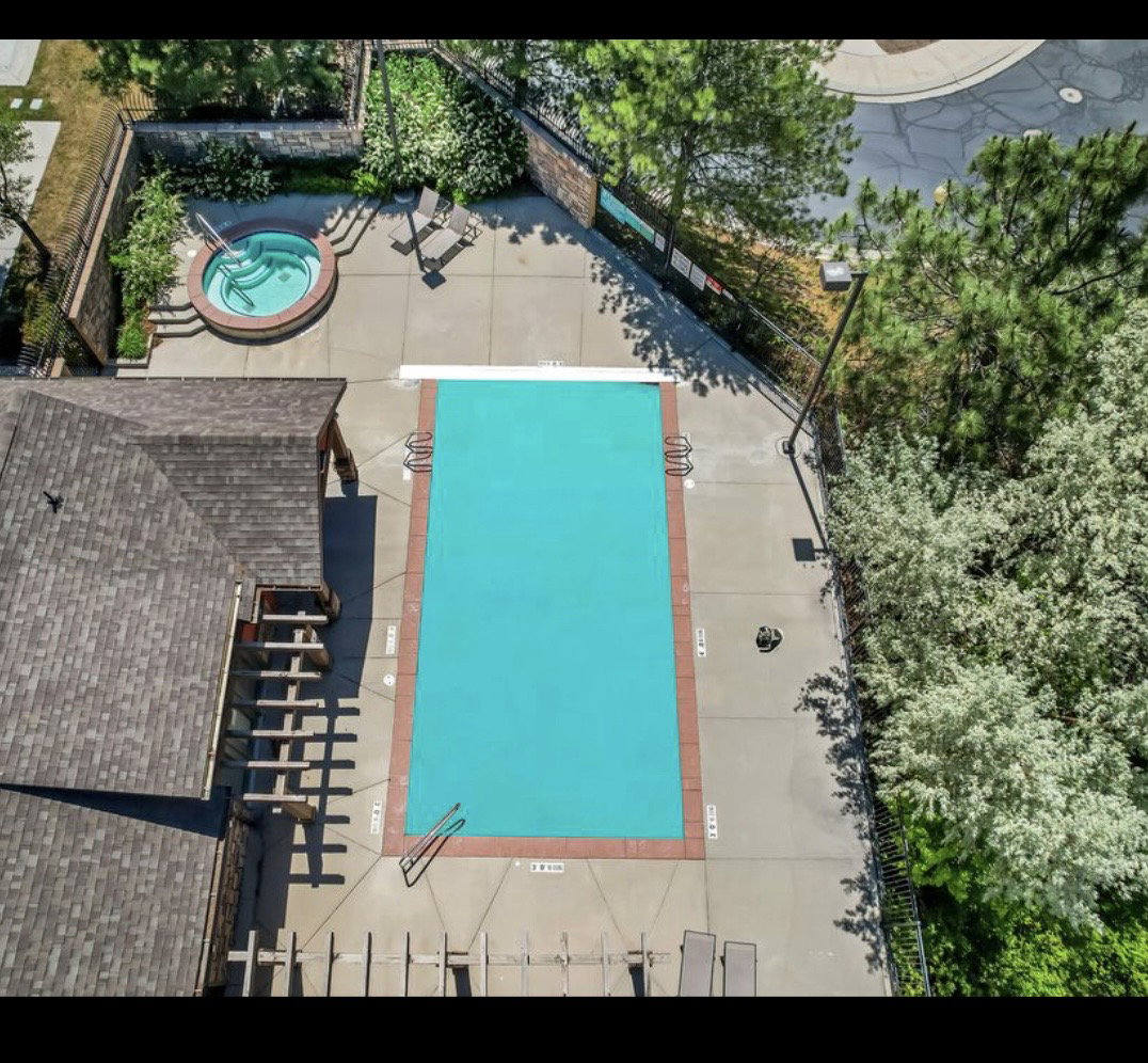 Rectangular swimming pool with a surrounding concrete deck and a separate circular spa