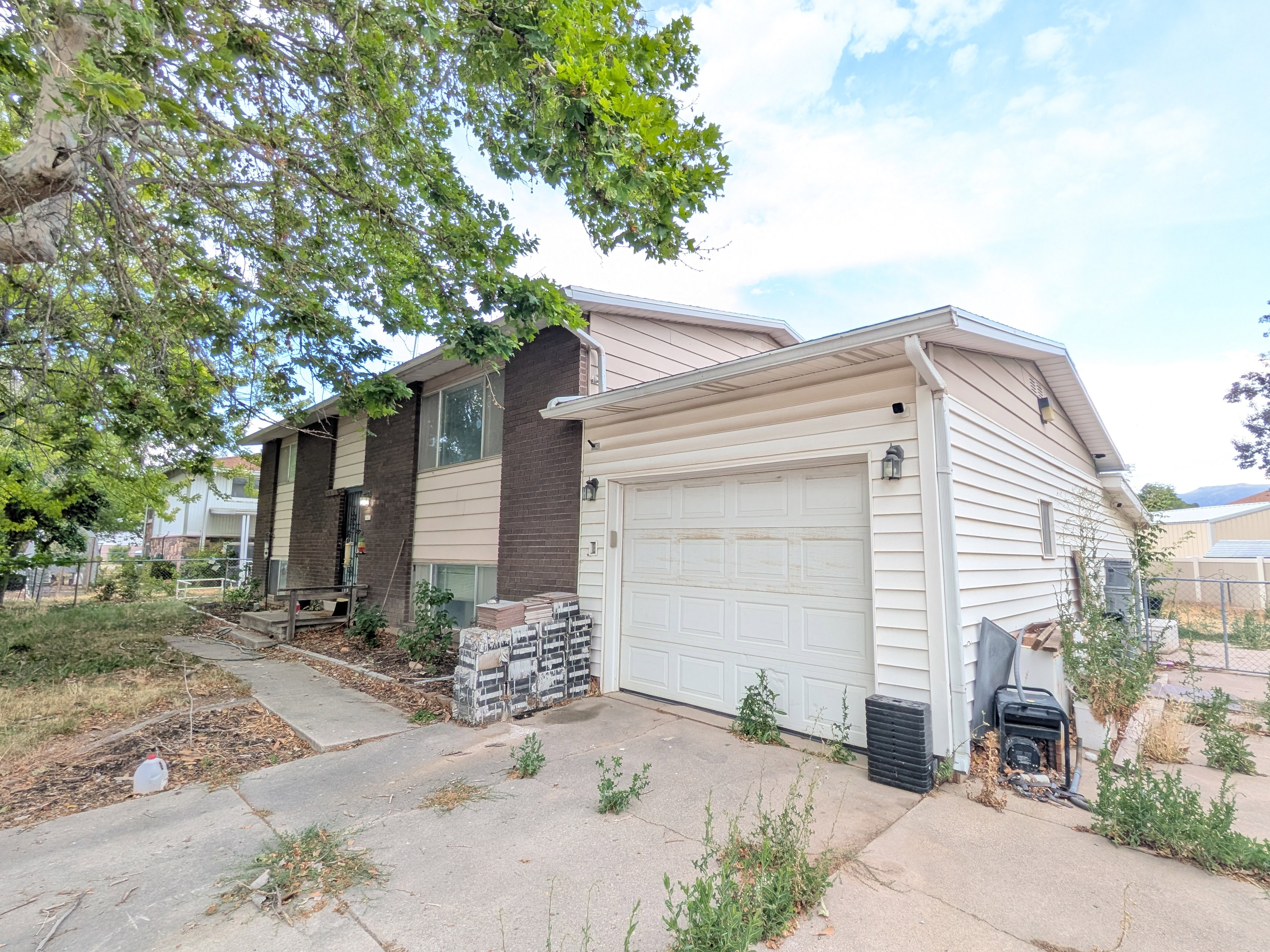 Multi-level residence featuring a two-car garage with a paneled door