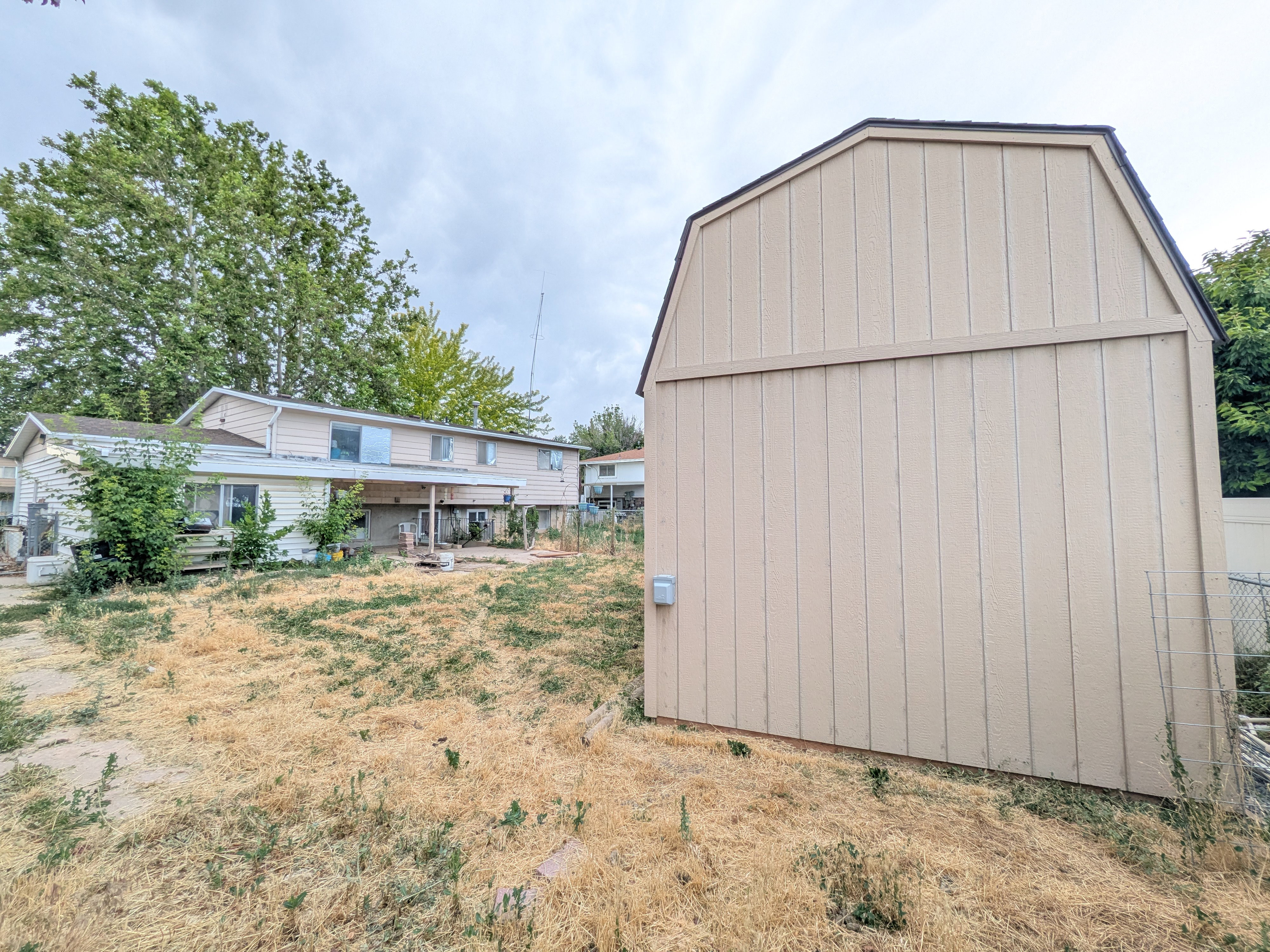 Freestanding outdoor shed with vertical panel siding and a gambrel roofline