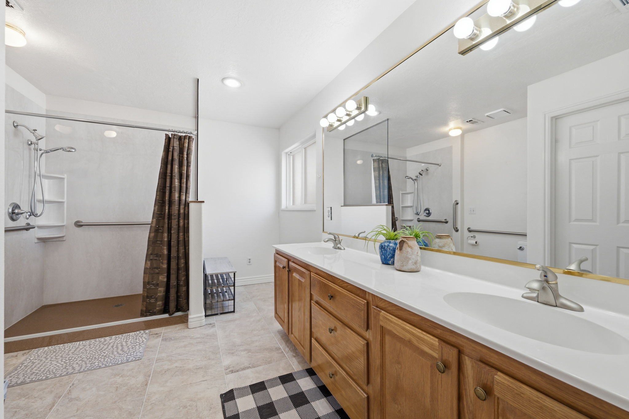 Bathroom featuring a double vanity with light wood cabinetry, white countertops, and dual undermount sinks