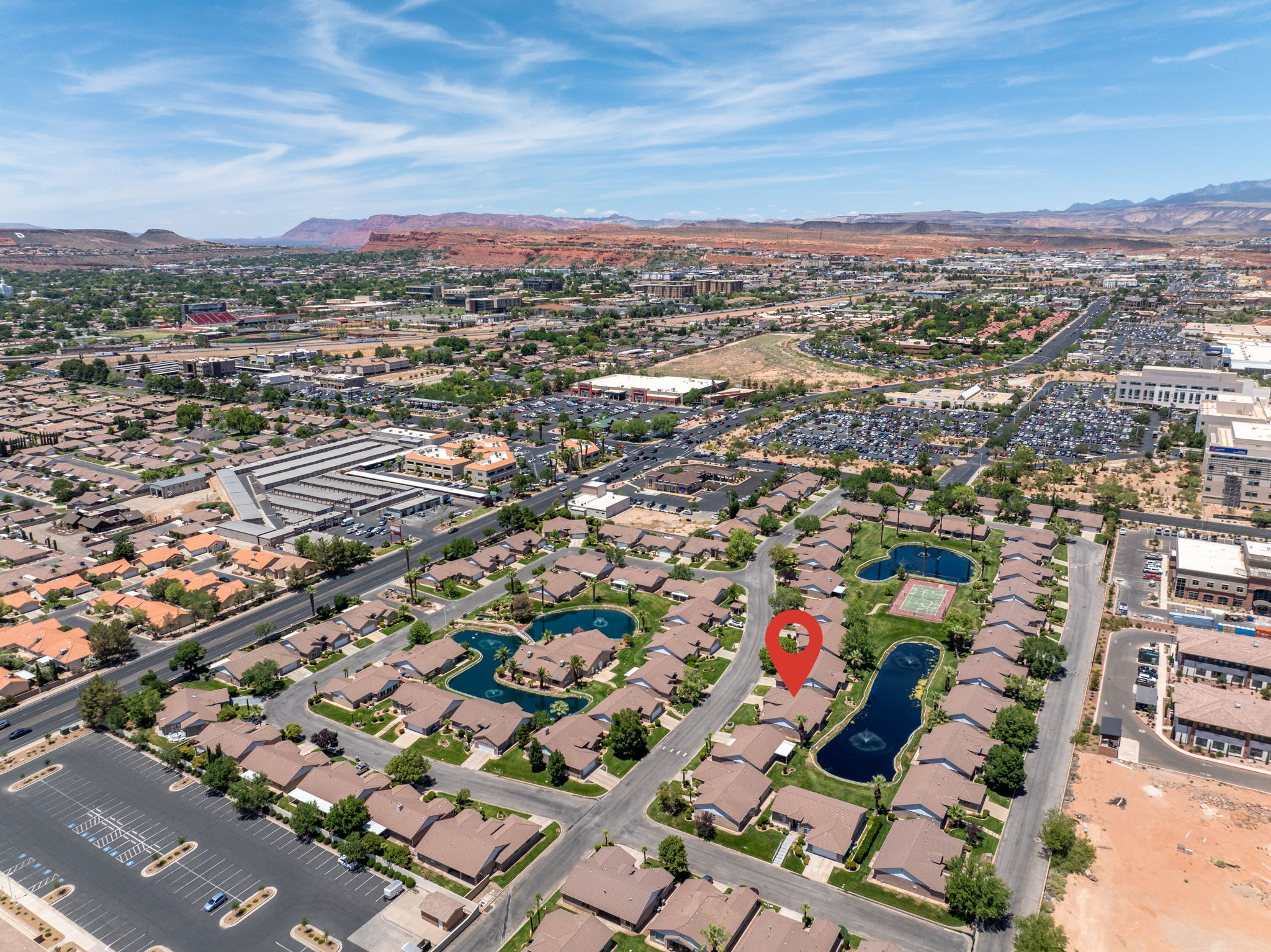 Aerial perspective of a residential community featuring multiple ponds and green spaces