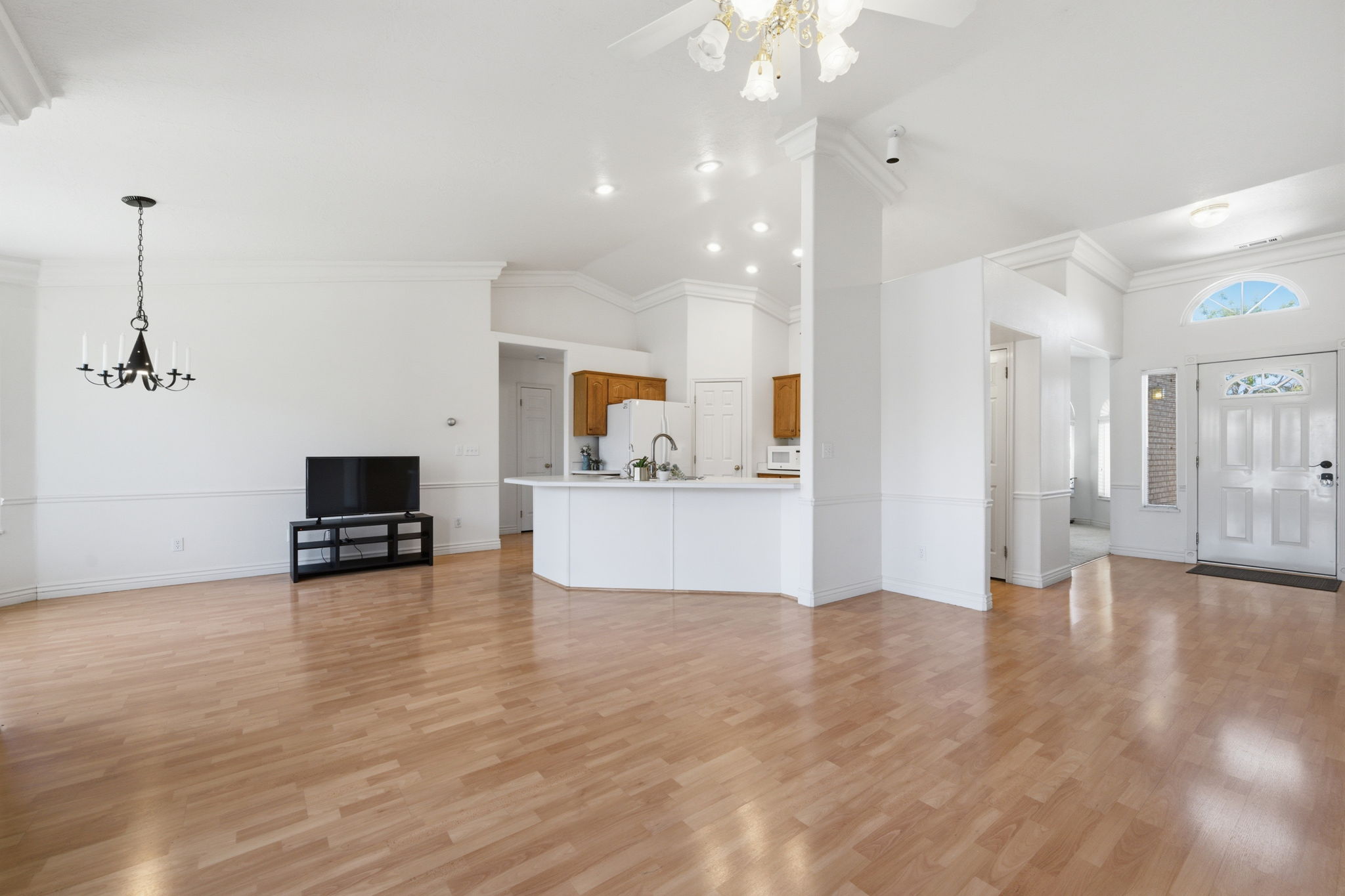 Bright living area featuring wood-finish flooring and crown molding