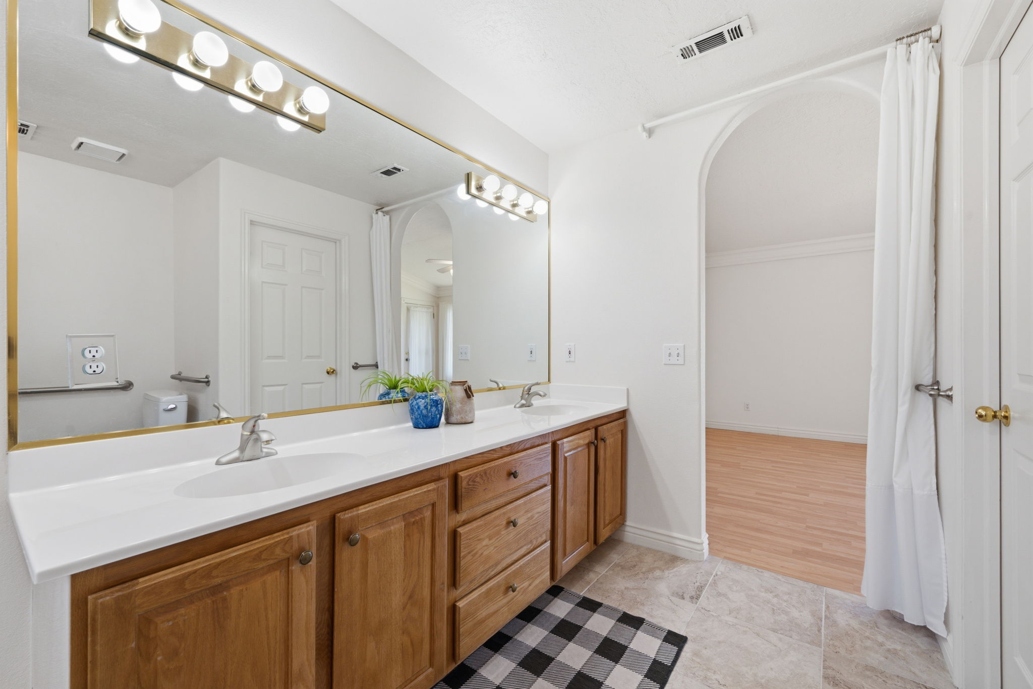 Dual vanity with light wood-finish cabinetry and white countertops
