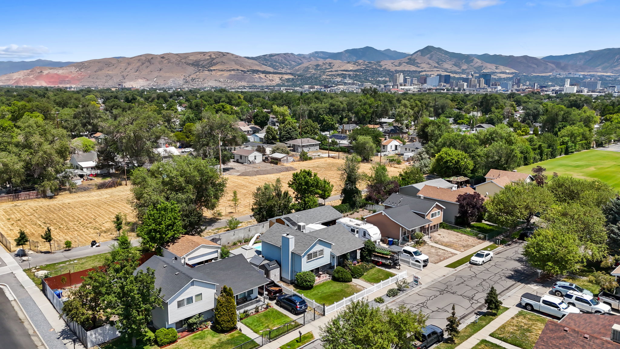 Residential street with established homes, mature trees, and landscaping