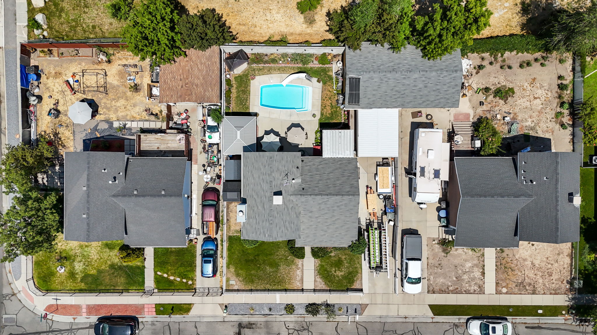 Aerial view showcasing multiple properties with dark shingle roofs