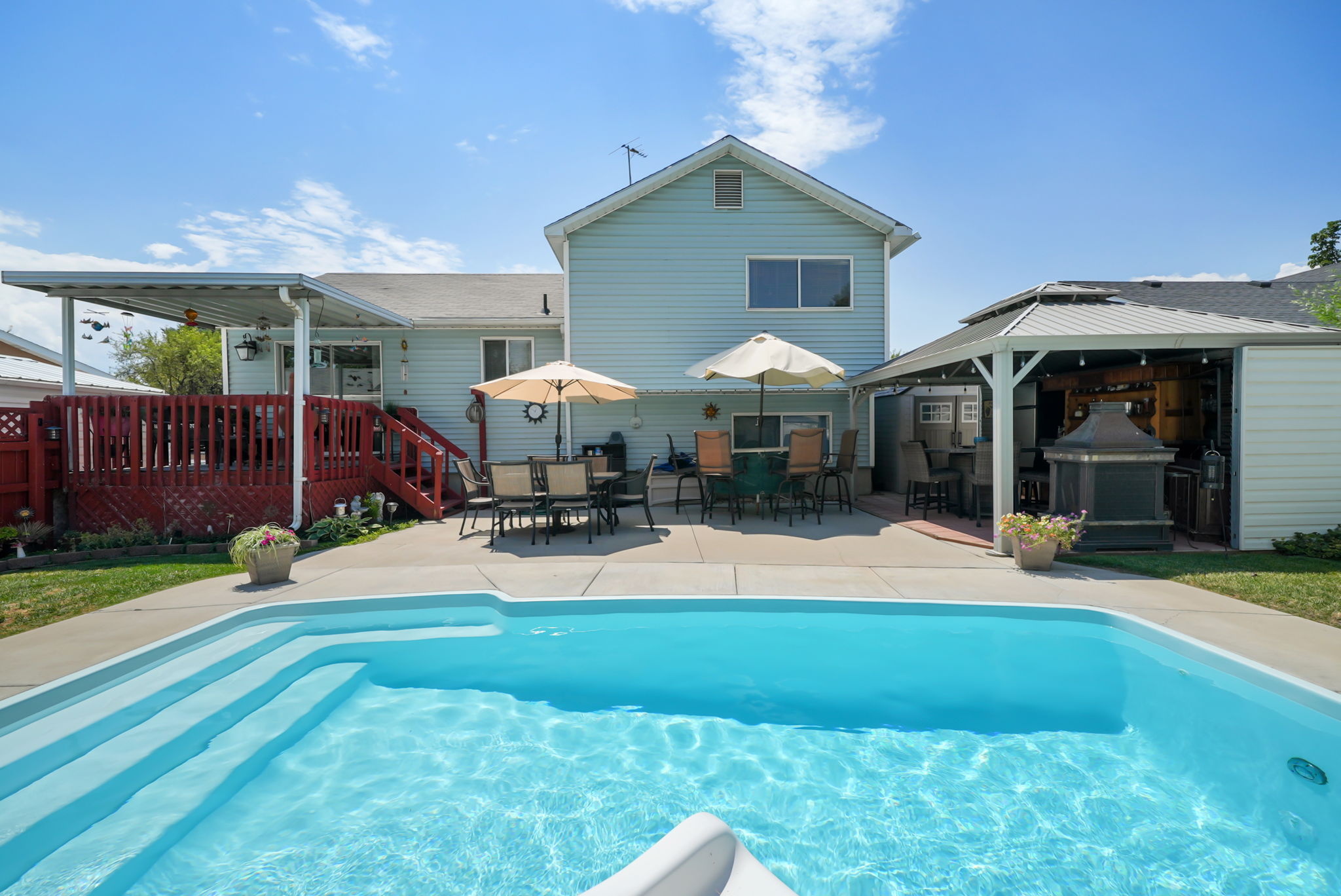 In-ground swimming pool with integrated steps, surrounded by concrete decking
