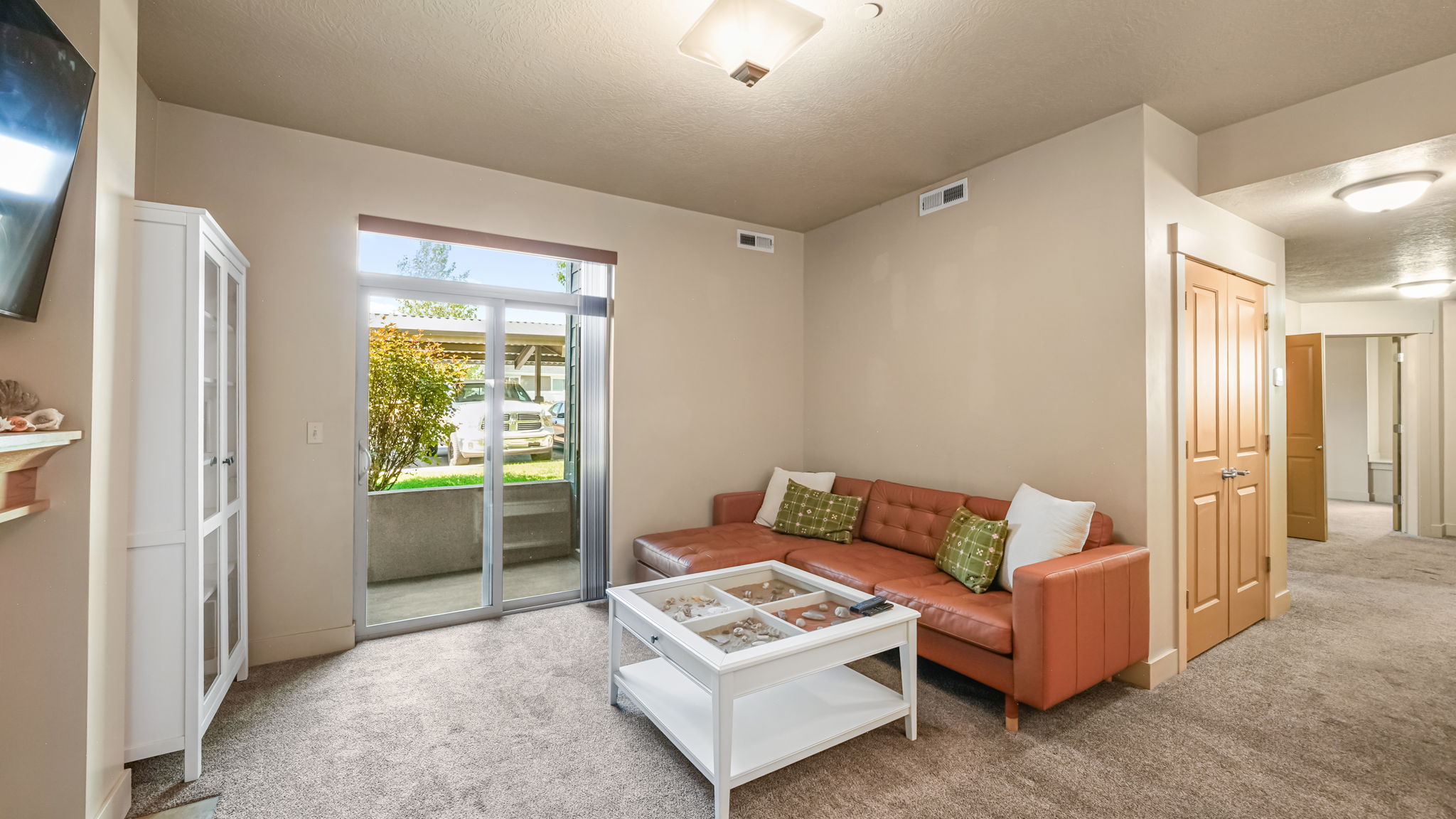 Living area featuring neutral wall tones and textured carpet flooring