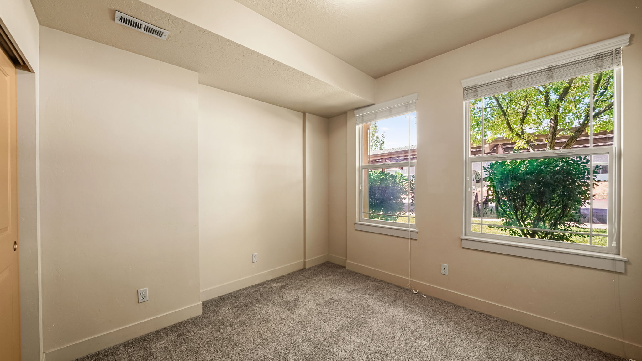 Neutral tone wall finishes, gray carpet flooring, white window blinds, and white trim