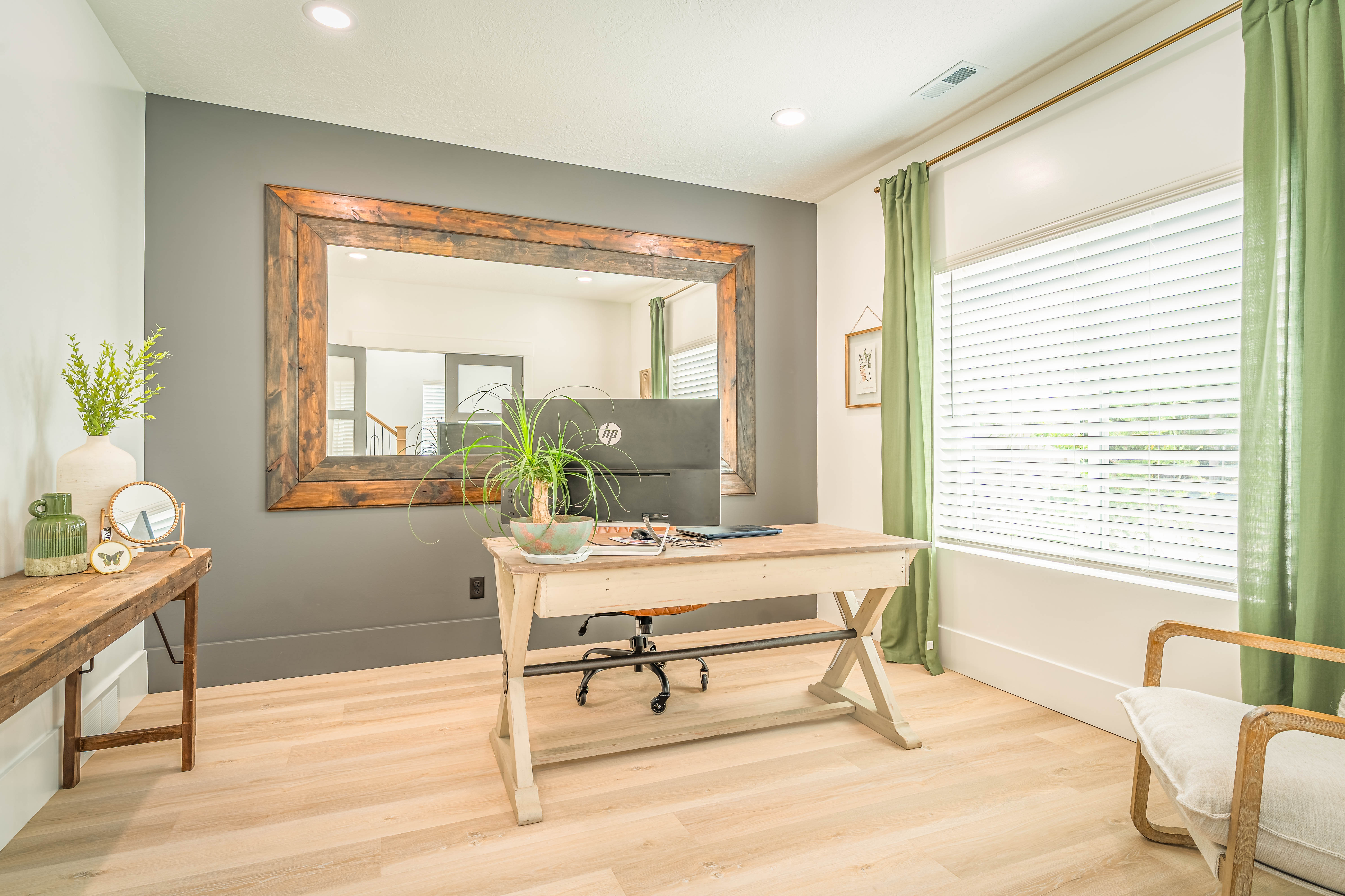 Spacious room featuring light wood-finish flooring, a large window with blinds, and recessed lighting