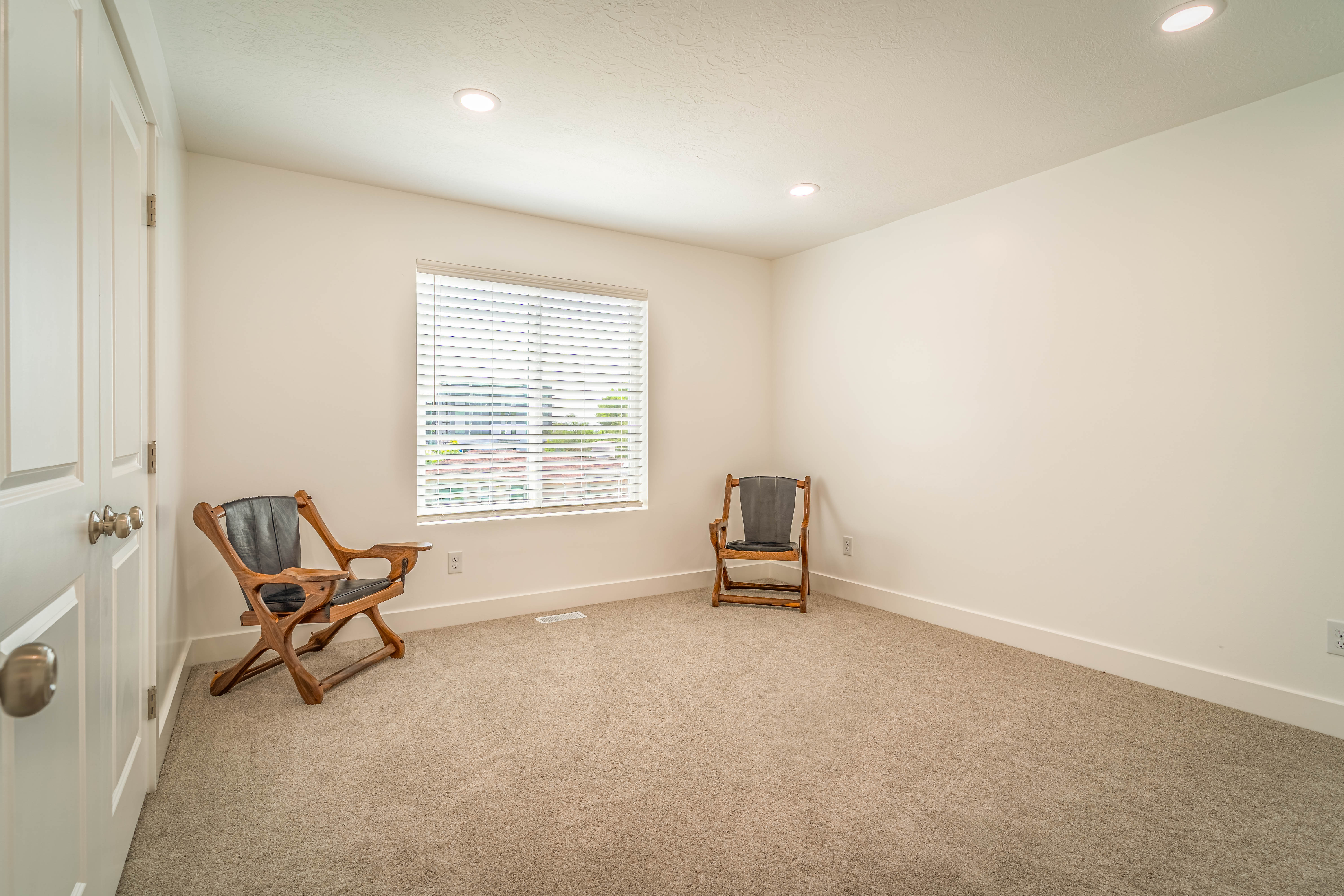 Bright room featuring neutral carpeting and white walls