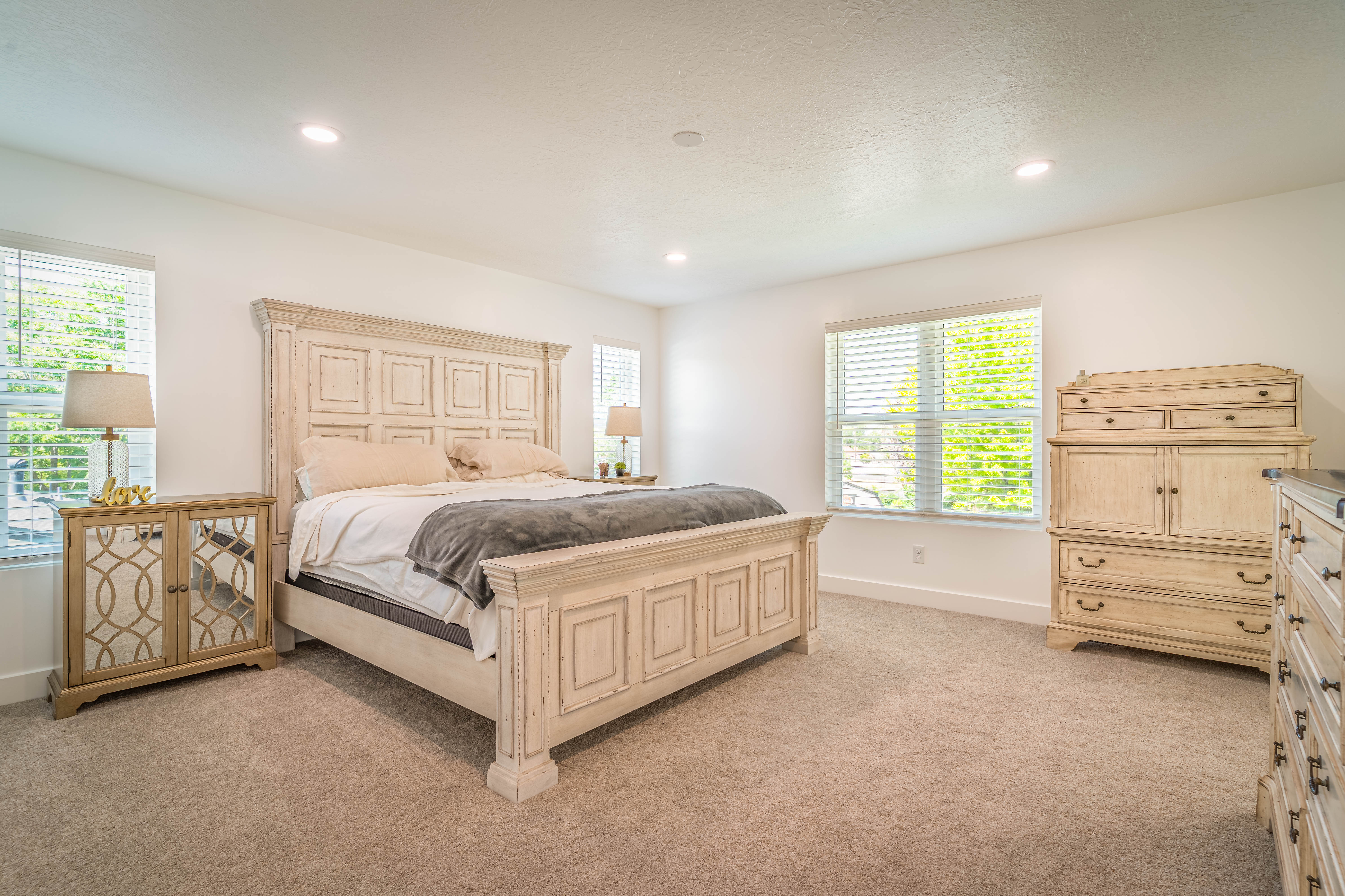 Spacious room featuring neutral carpeting, recessed lighting, and white walls