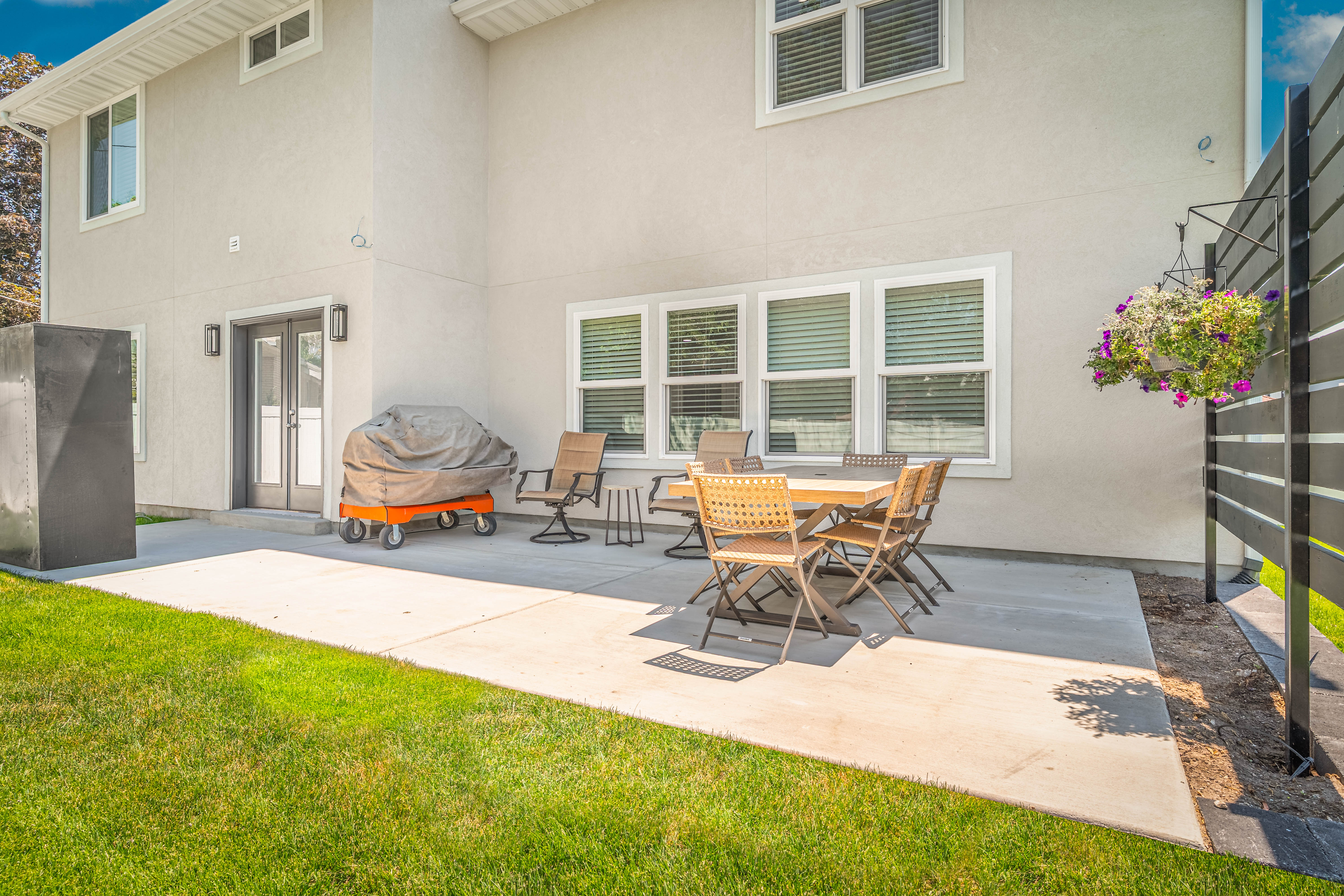 Expansive concrete patio with direct outdoor access via double French doors