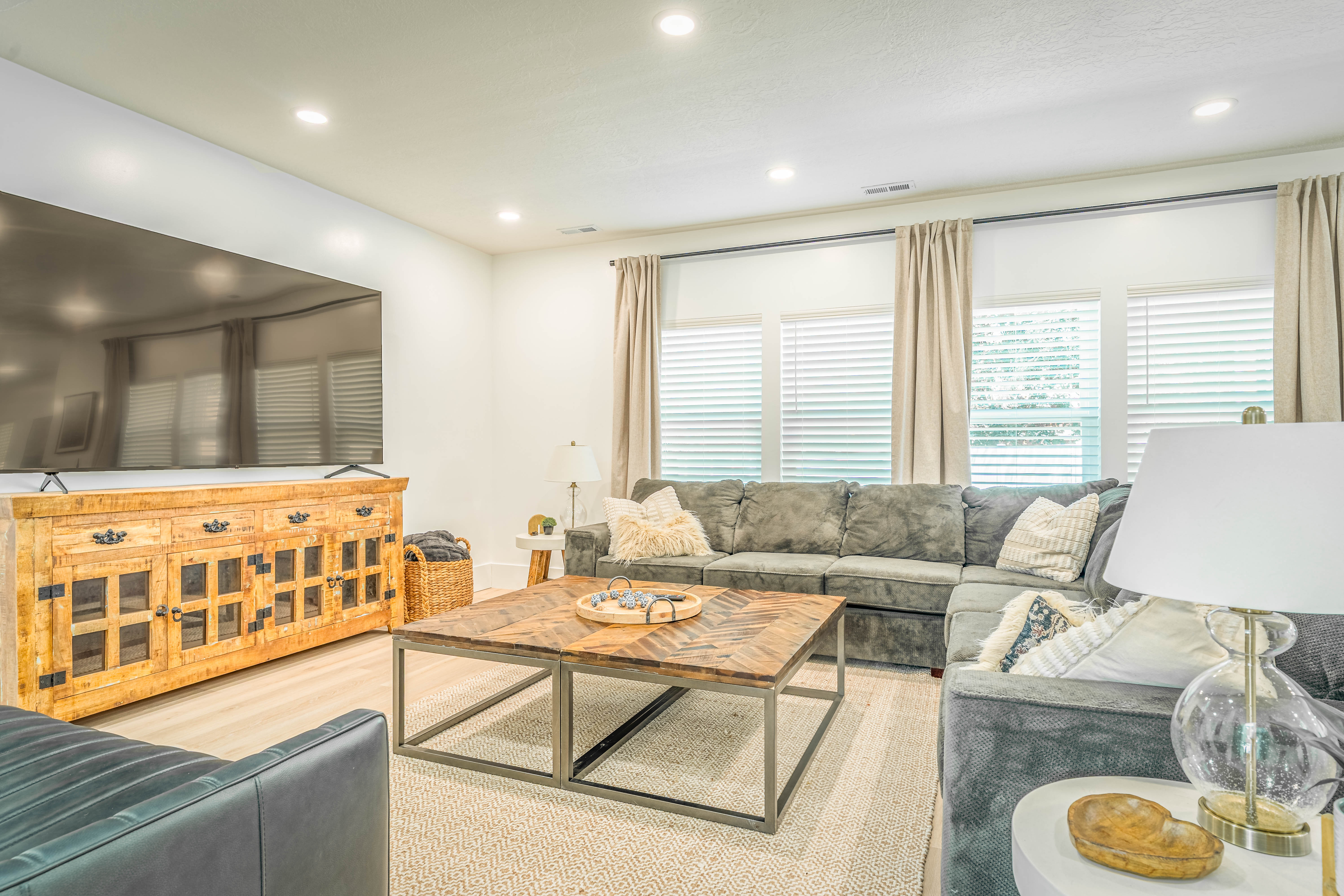 Living area featuring recessed lighting, light-toned wood-finish flooring, and multiple windows with blinds