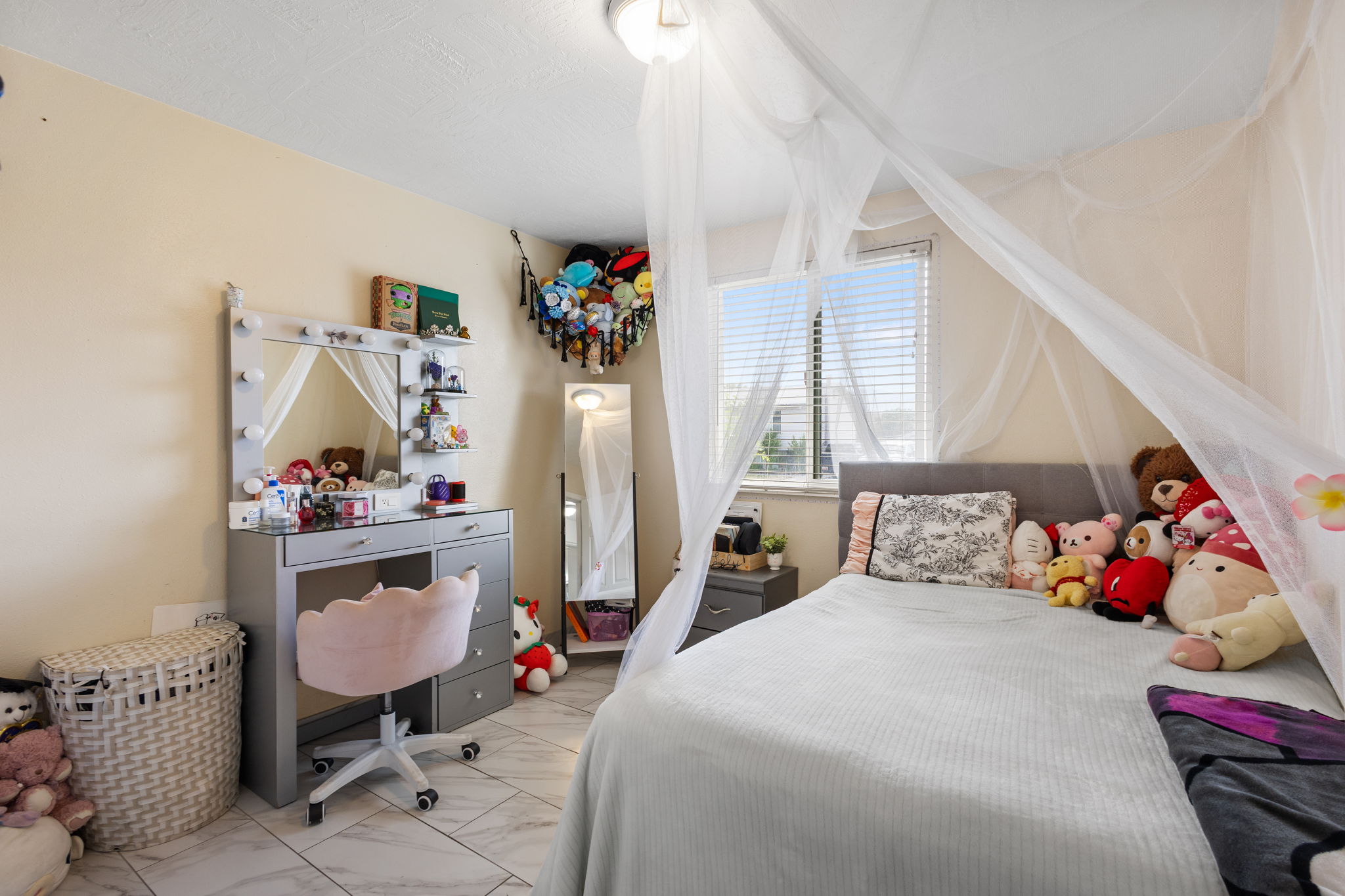 Bedroom featuring tiled flooring and a window with horizontal blinds
