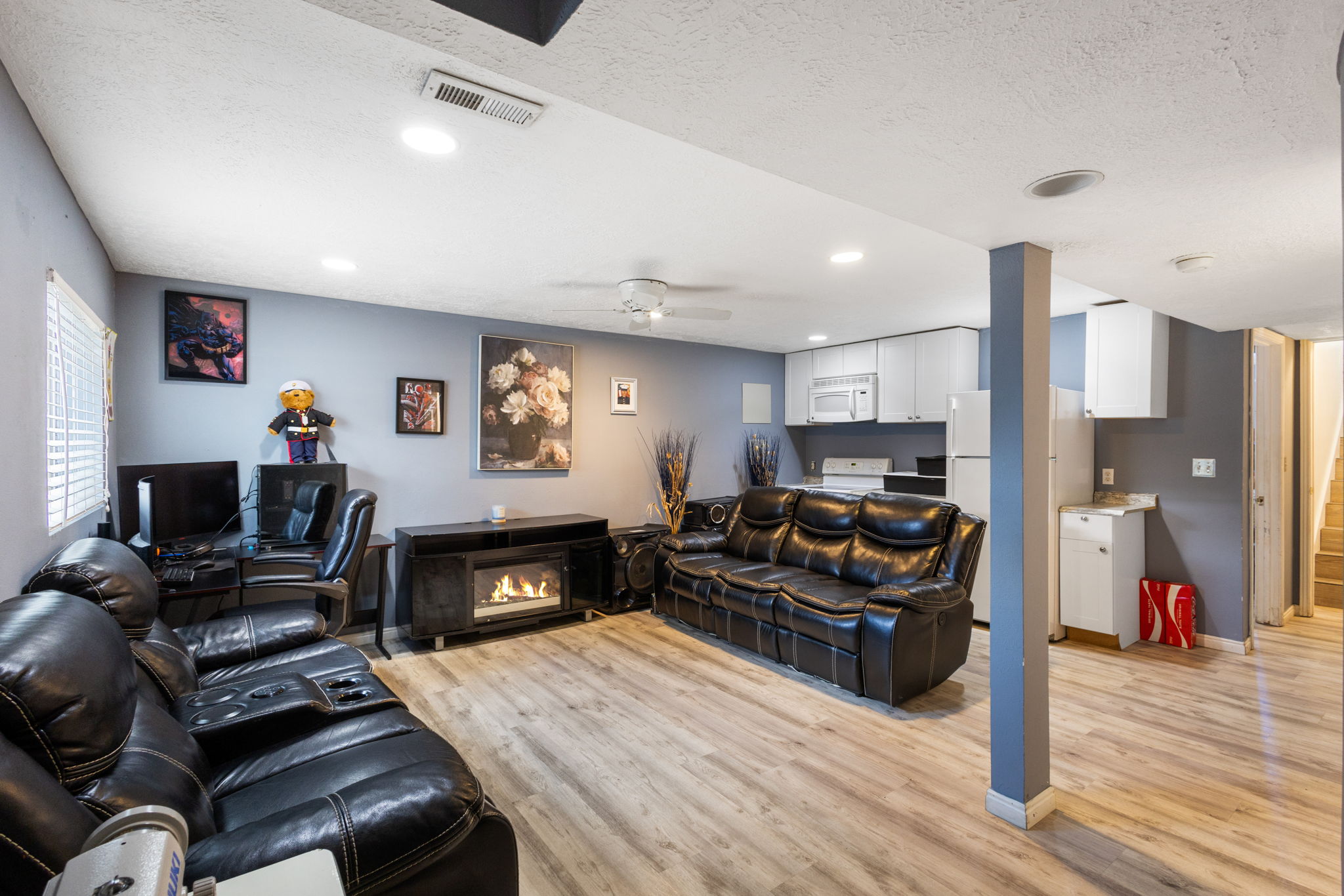 Recreation room featuring wood-finish flooring, recessed lighting, and a built-in electric fireplace
