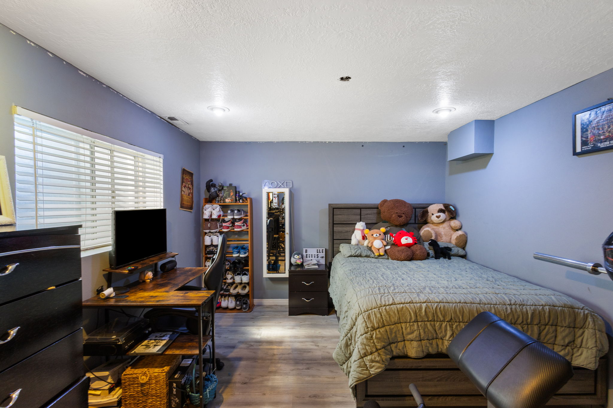 Bedroom featuring wood-finish flooring, recessed lighting, and a window with horizontal blinds
