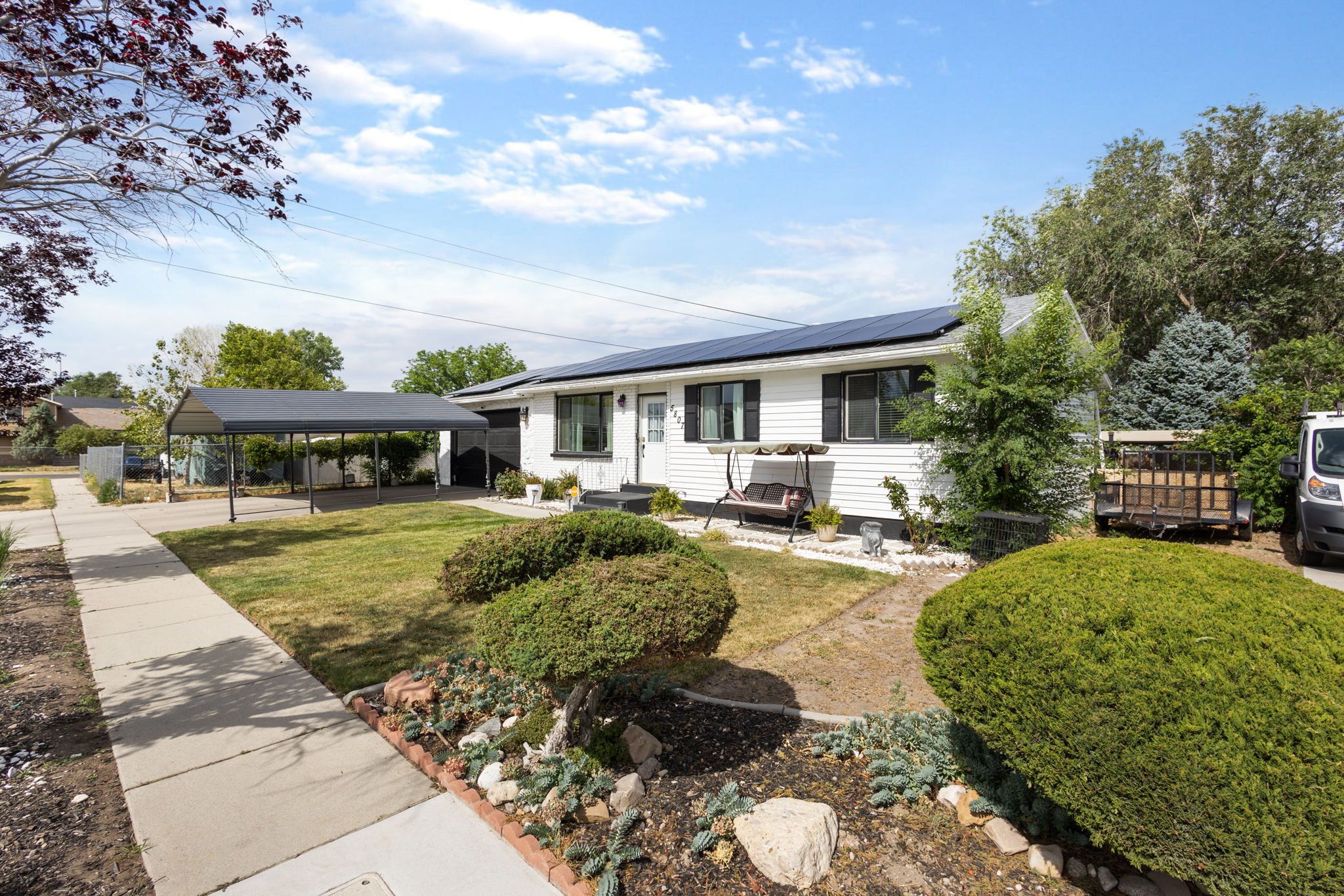 White siding exterior with black shutters and solar panels