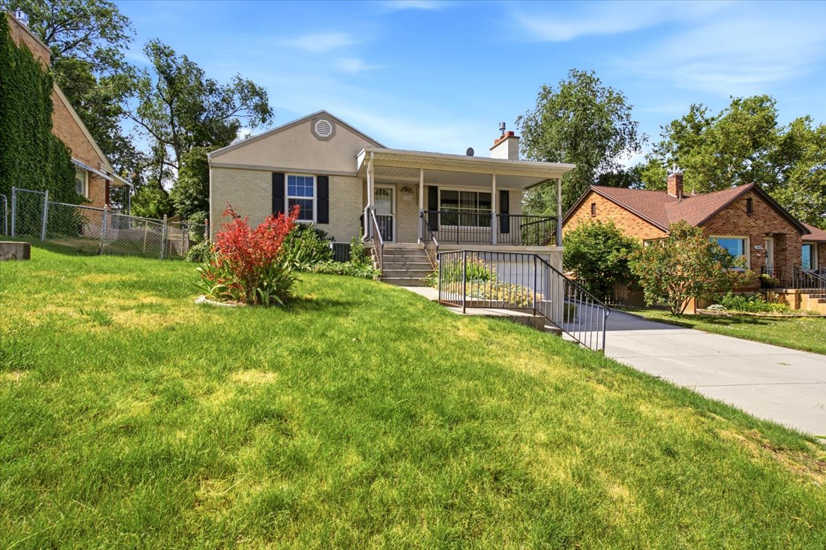 Front exterior featuring a covered porch, established landscaping, and a concrete driveway