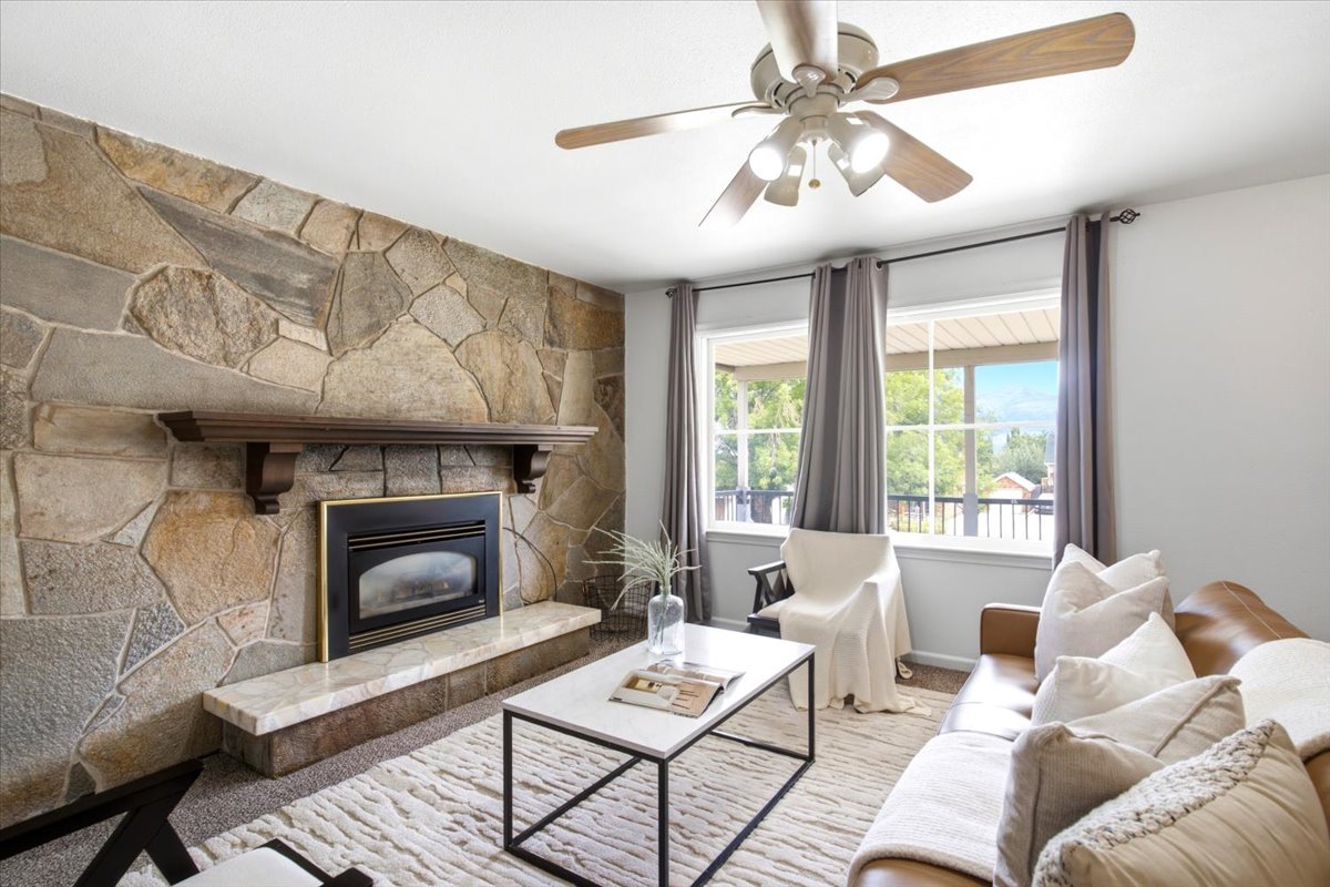 Living area featuring a stone accent wall with an integrated fireplace and wood mantel