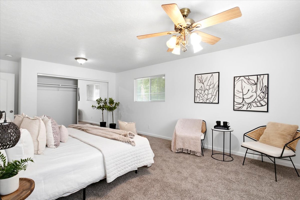 Carpeted bedroom featuring a ceiling fan with light fixture, recessed lighting, and a window for natural light