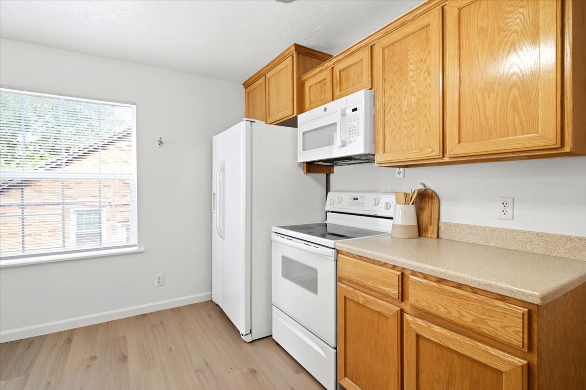 Kitchen featuring wood-finish cabinetry and light-toned countertops