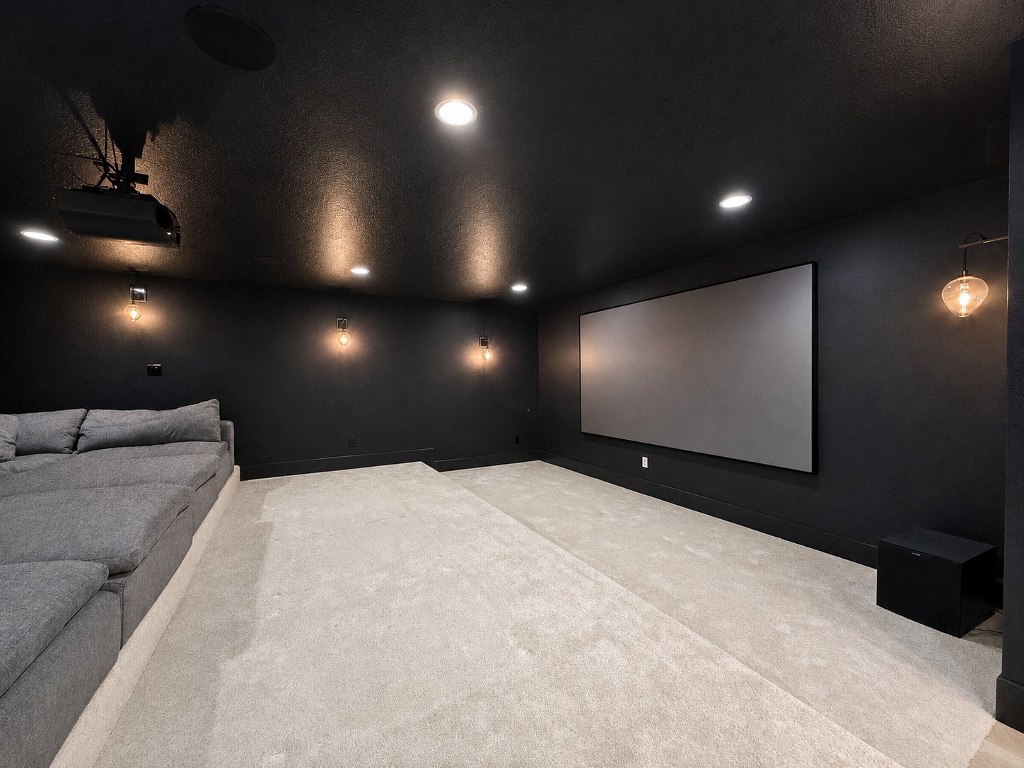 Media/theater room featuring a 135" projection screen, Sony overhead projector, theater lighting with RH Cloud couch seating and carpet.