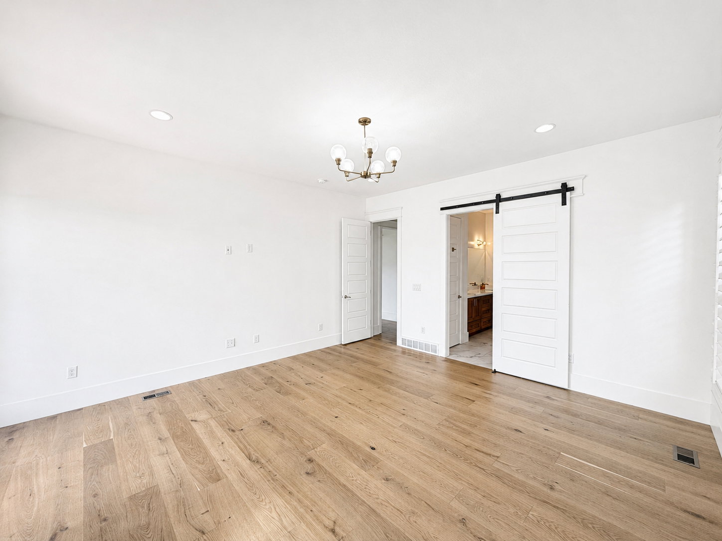 First floor primary with wood flooring and recessed lighting